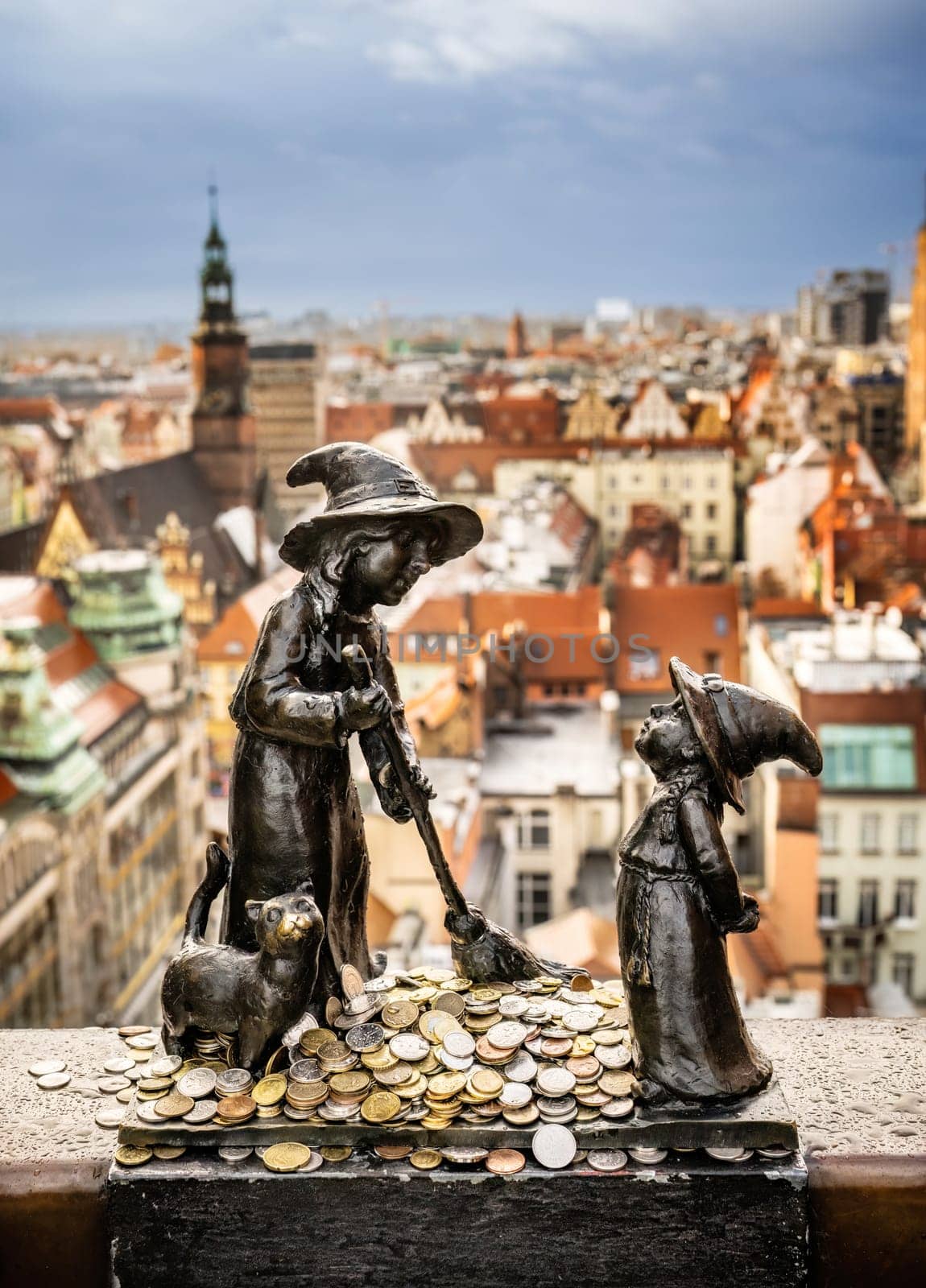 Gnome sculpture in Wroclaw with coins against amazing Wroclaw city view. Tradition dwarf statues of Wroclaw - so-called calling card of the city.