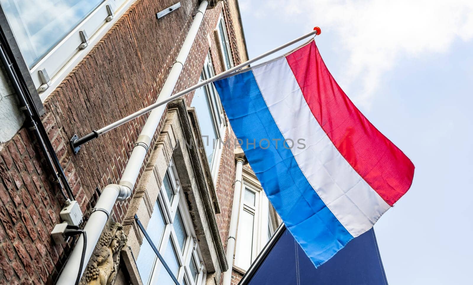 Netherlands flag on fasad building against Blue Sky