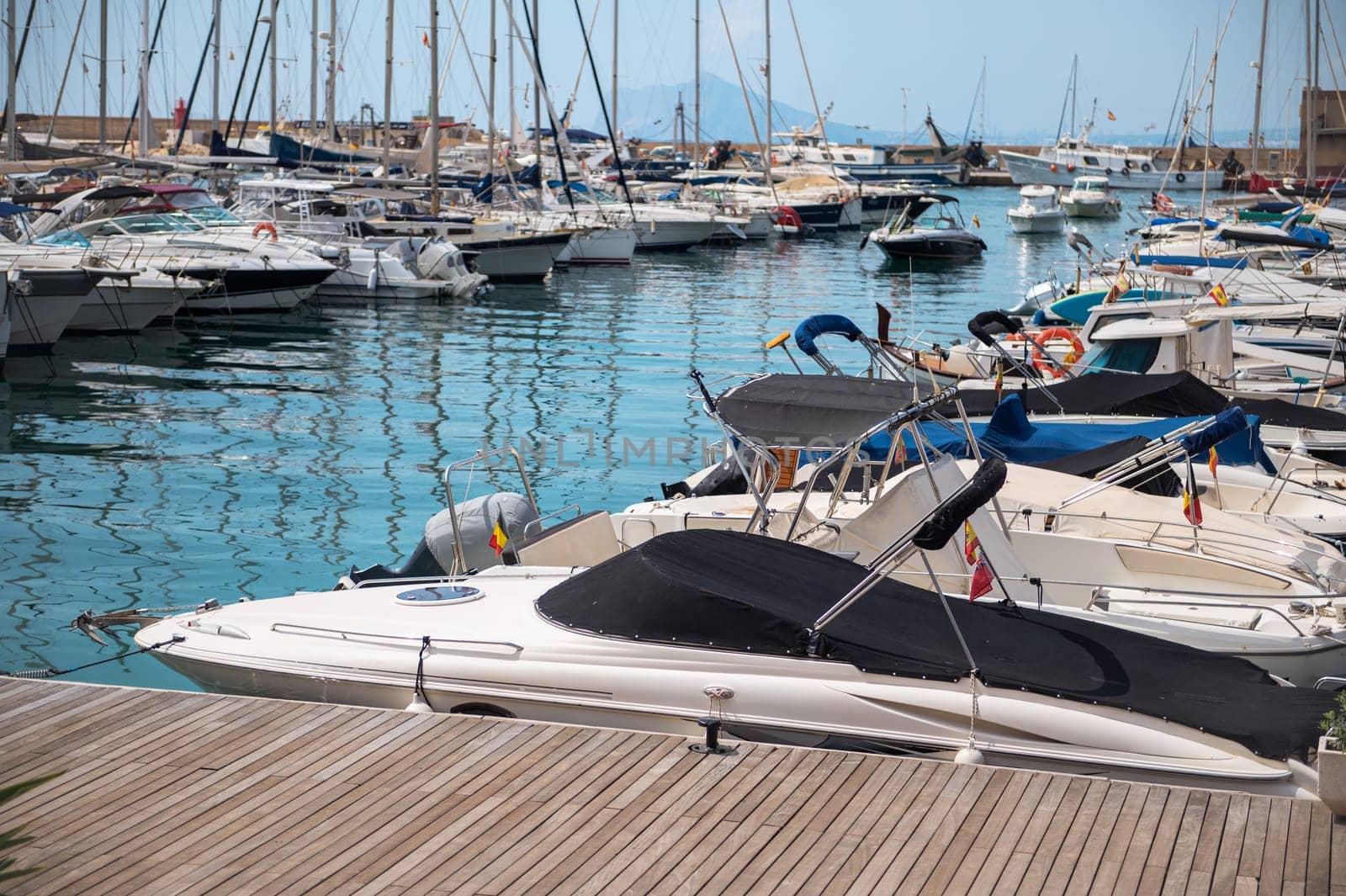 A vibrant marina filled with numerous yachts and boats docked under a bright, clear sky, offering a serene nautical ambiance.