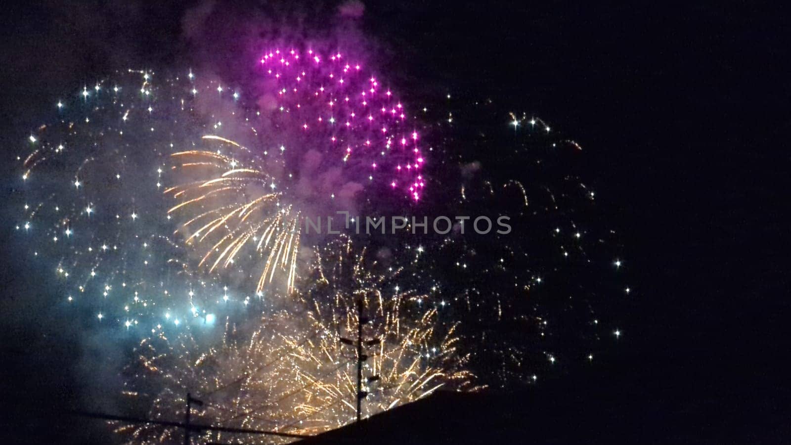 Bright bursts of fireworks light up the night sky, creating a stunning display of colors during a festive celebration, capturing the joy of the moment.