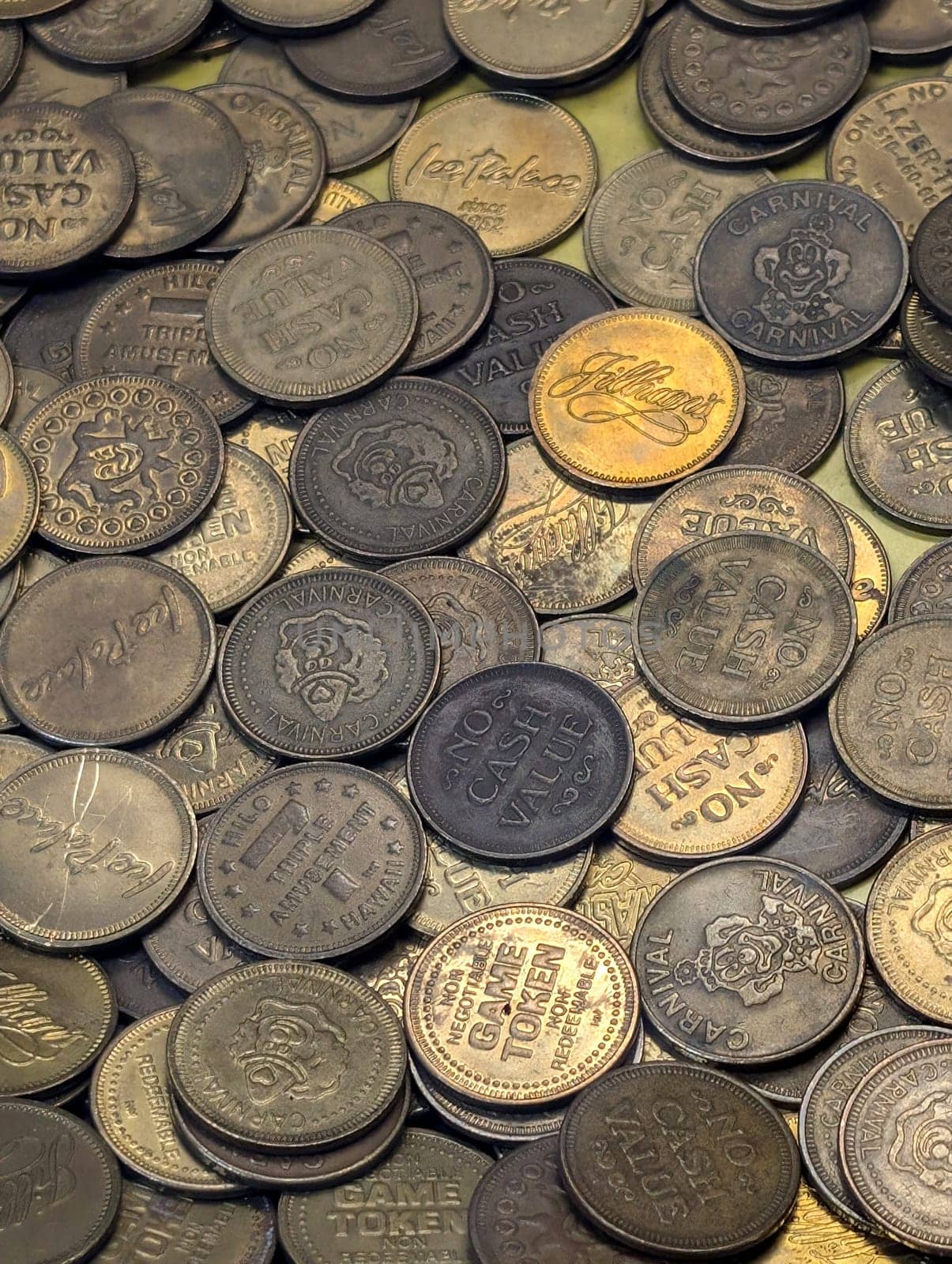 Honolulu - July 16, 2024: A variety of game tokens lie scattered across a table, showcasing different denominations and designs from a family entertainment locations in Hawaii including Carnival Carnival, Ice Palace, Jillians.