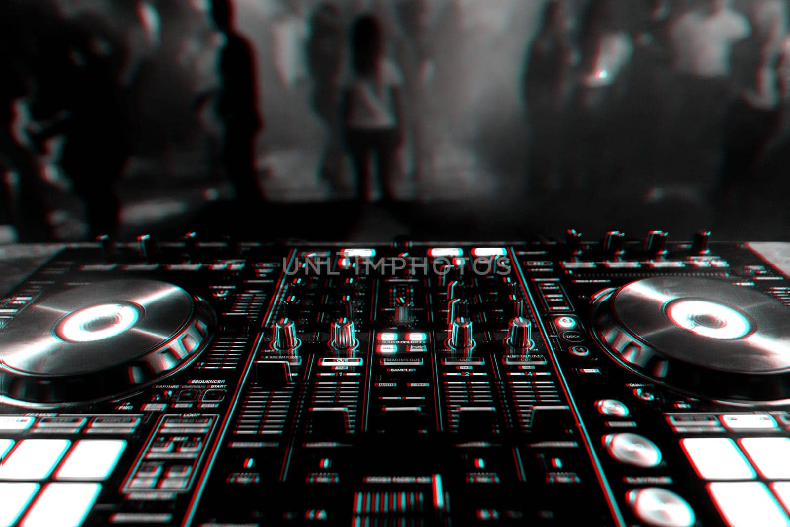 DJ mixer controller Board for professional mixing of electronic music in a nightclub at a party with dancing people in the background. Black and white photo with glitch effect and small grain