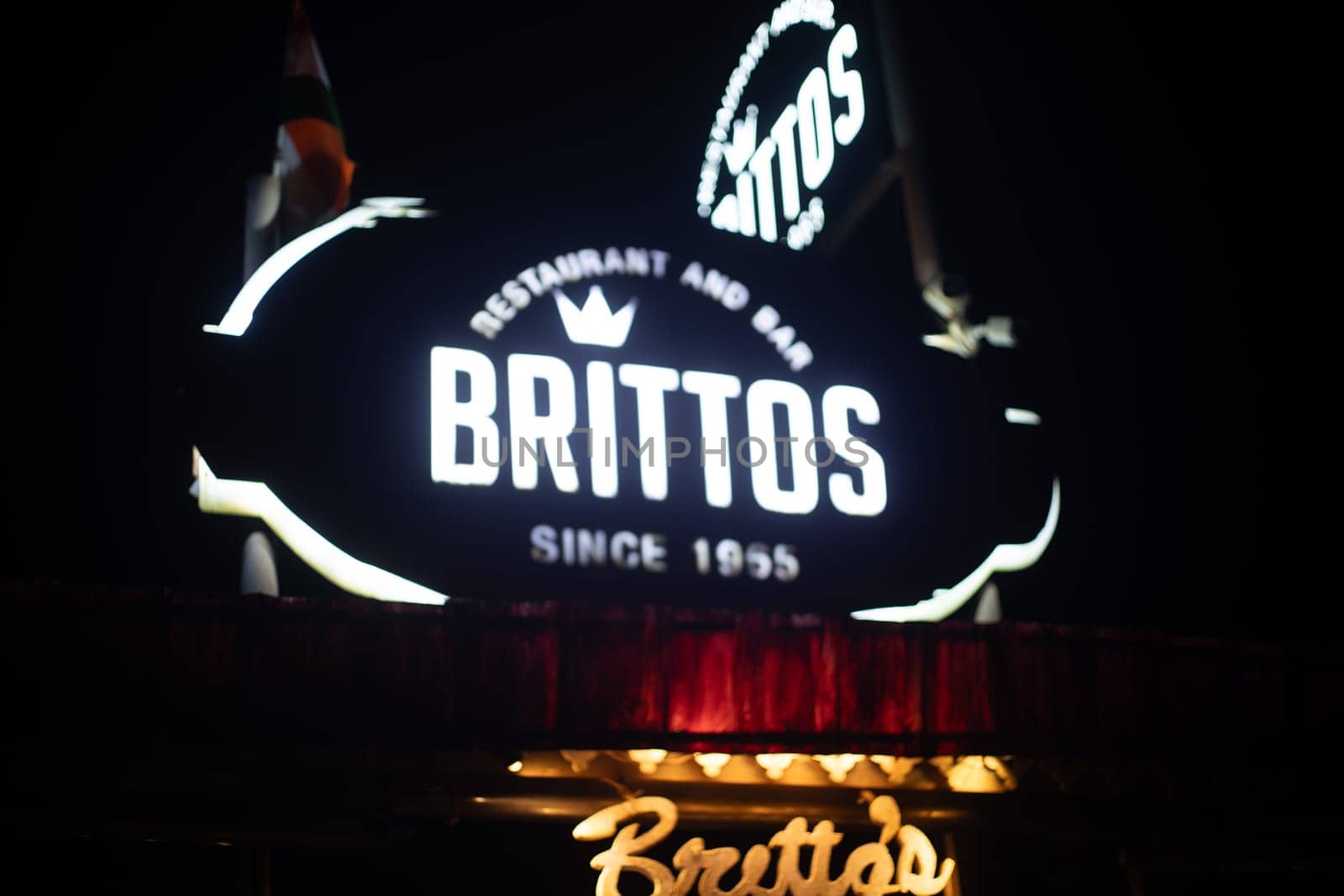 Goa, India - 16th Aug 2024: Night lit sign showing famous shack Brittos on baga beach with colorful lights popular tourist spot for dining on sand karaoke and more