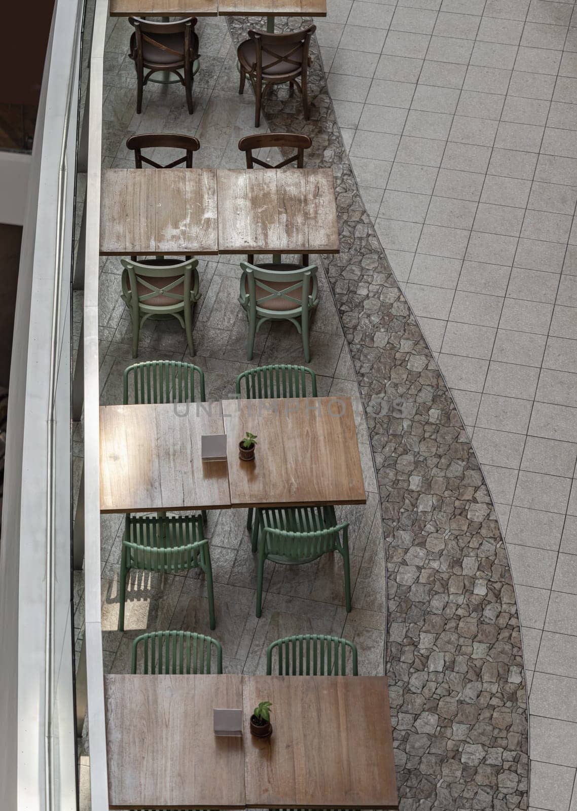 Bangkok, Thailand - 28 Sep, 2024 - Looking down at Wooden tables and green chairs. Area in restaurant inside the shopping mall. Space for text, Selective focus.