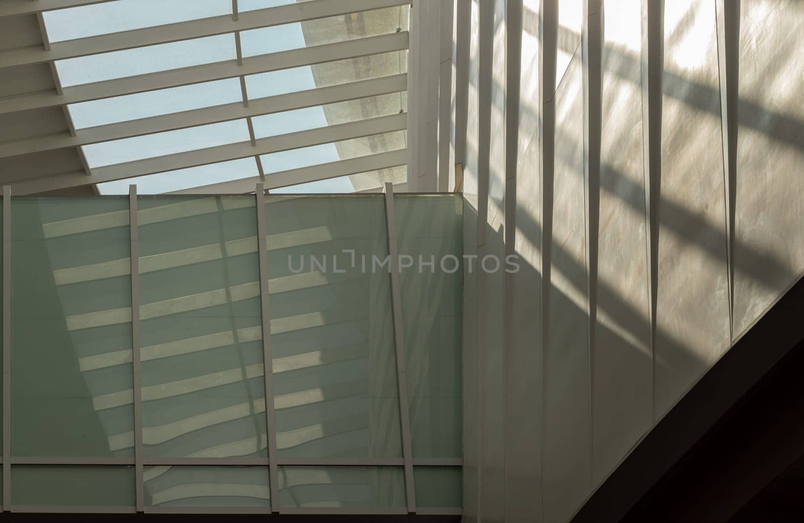 Bangkok, Thailand - 28 Sep, 2024 - Modern architecture interior design of metal structure building with Burred light and shadow passing through glazed ceiling. Abstract image of Sunlight shining through a glass roof and creating shadows on a wall, Copy space, Selective focus.