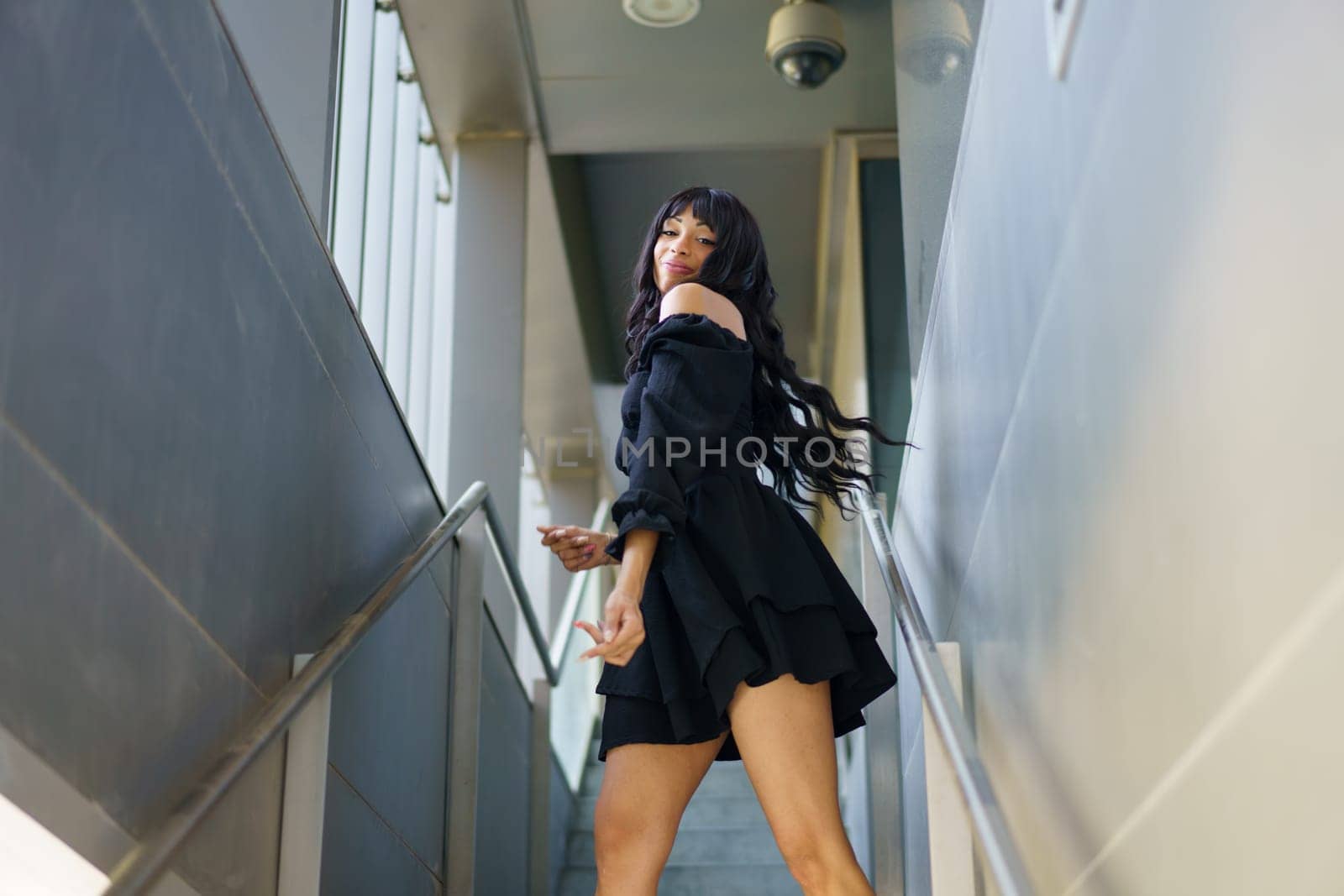 Low angle view photo of a female caucasian dancer moving sensually standing on urban stairs