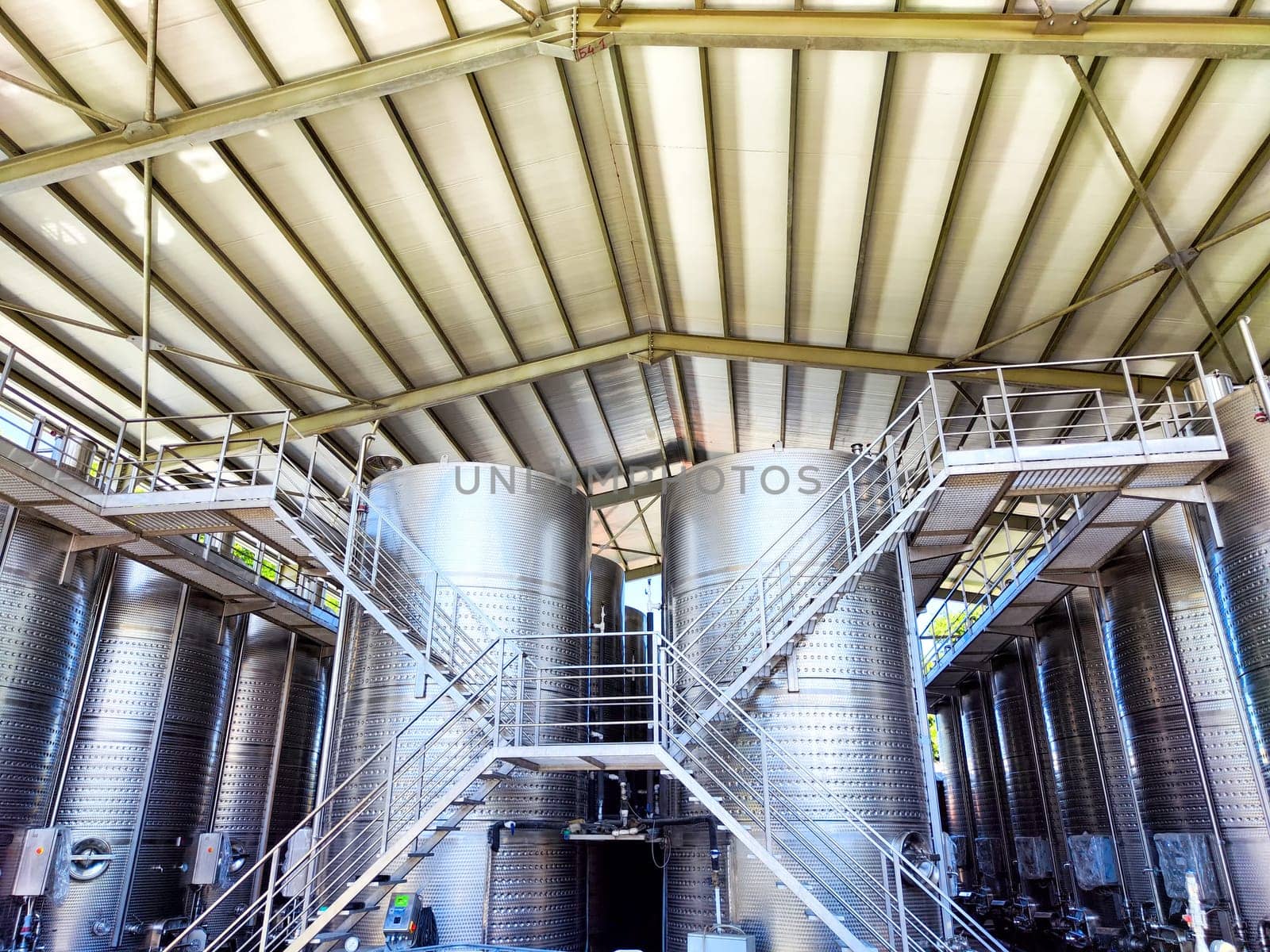 The interior of Kindzmarauli Winery displays stainless steel fermentation tanks used for wine production in Georgia.