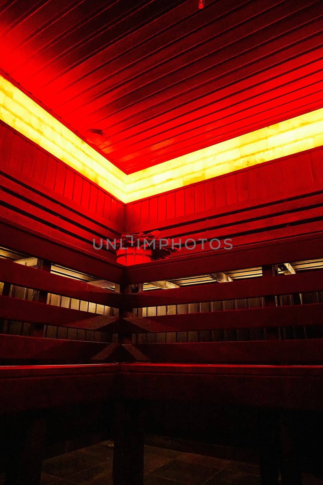 Modern sauna with red lighting and wooden walls
