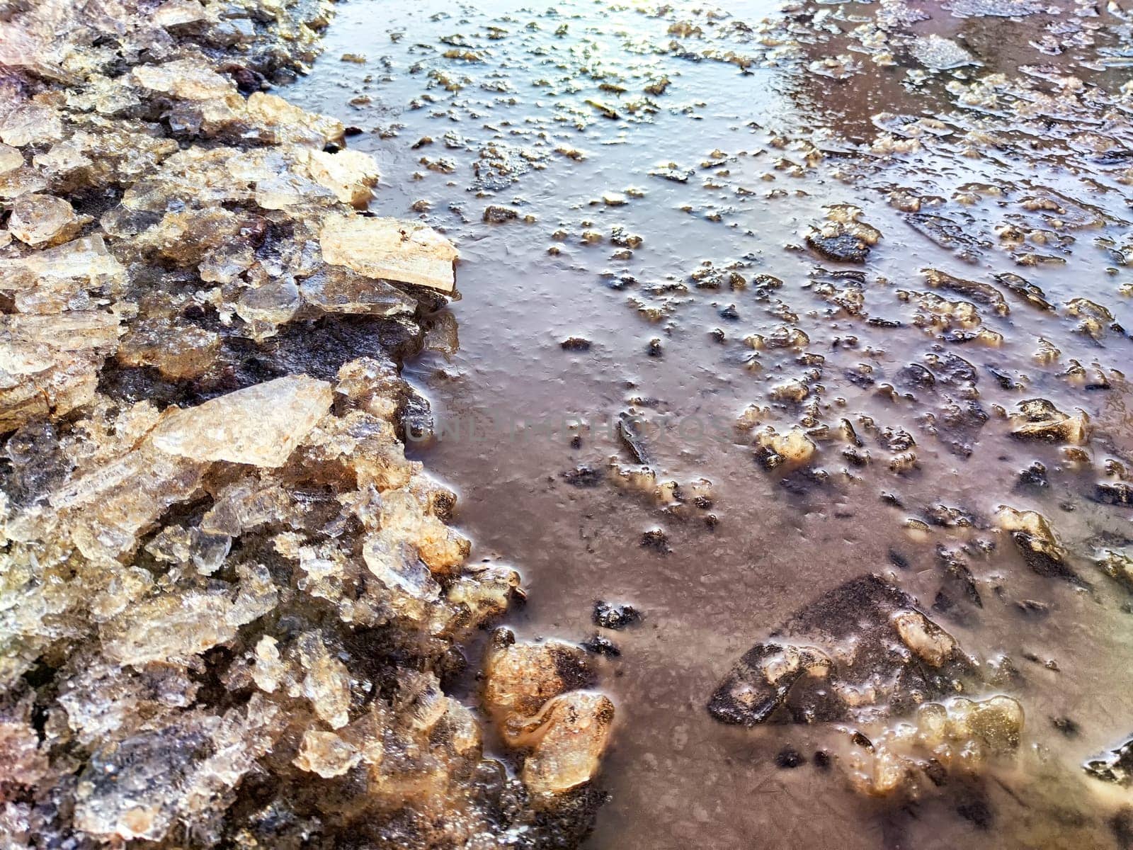 Ice and water in spring in flood. Puddle. Background, texture, pattern, frame, copy space. puddle with melted ice and water in the spring