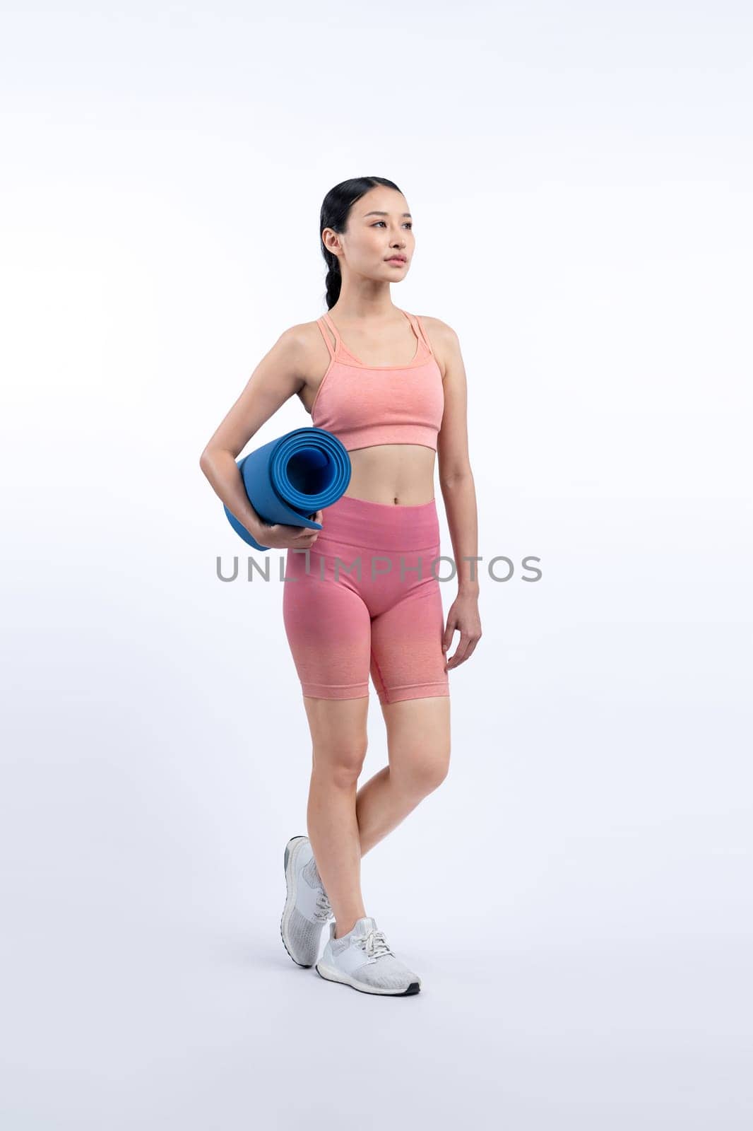 Young attractive asian woman portrait in sportswear with exercising mat. Healthy exercise and workout routine lifestyle concept. Studio shot isolated background. Vigorous