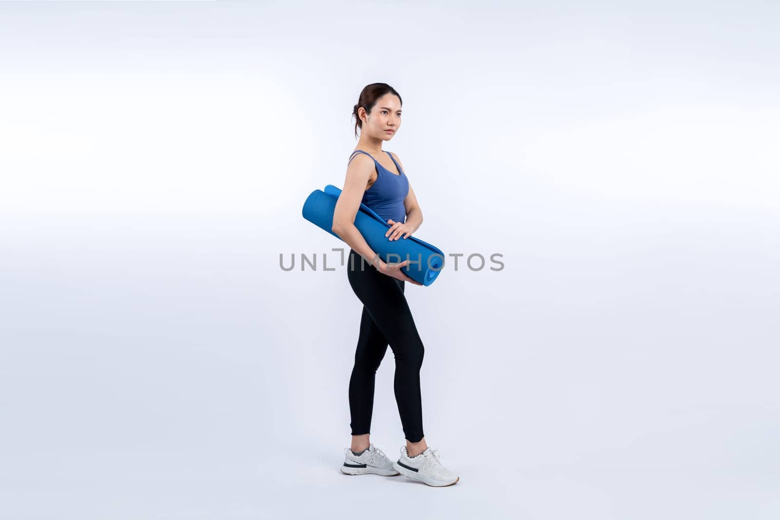 Young attractive asian woman portrait in sportswear with exercising mat. Healthy exercise and workout routine lifestyle concept. Studio shot isolated background. Vigorous