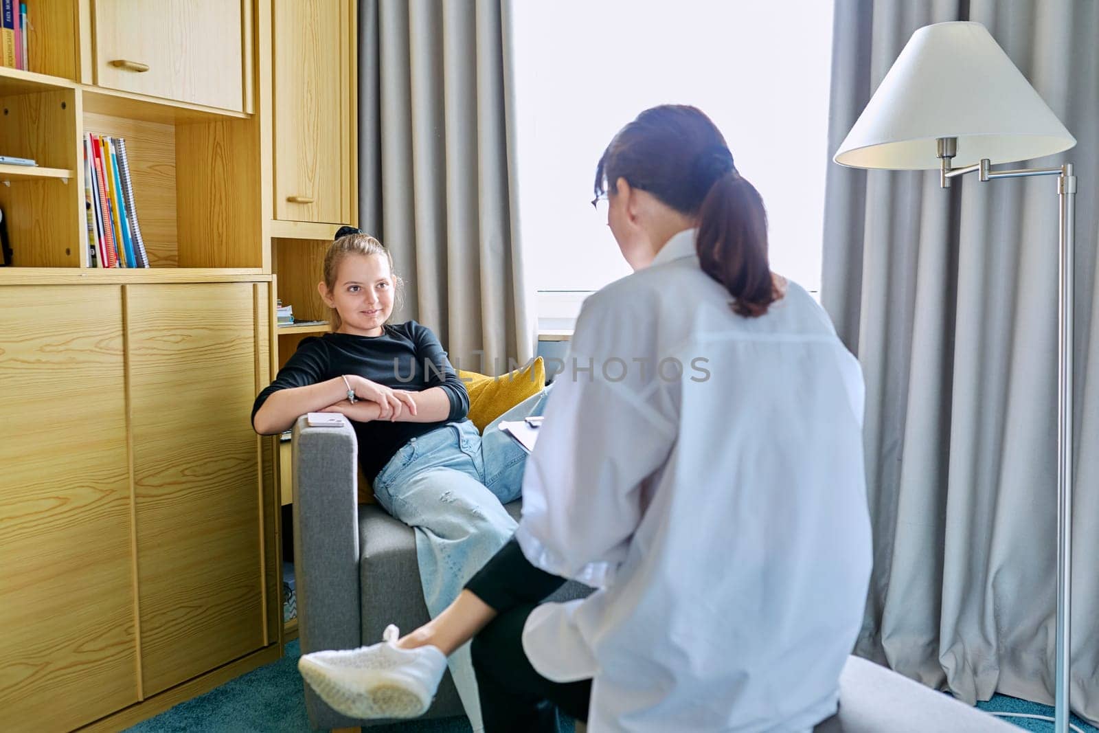 Girl child 10 years old at therapy session with psychologist. School counselor talking to child, listening, helping with problem. Mental health, childhood, schoolchildren, psychology, psychotherapy