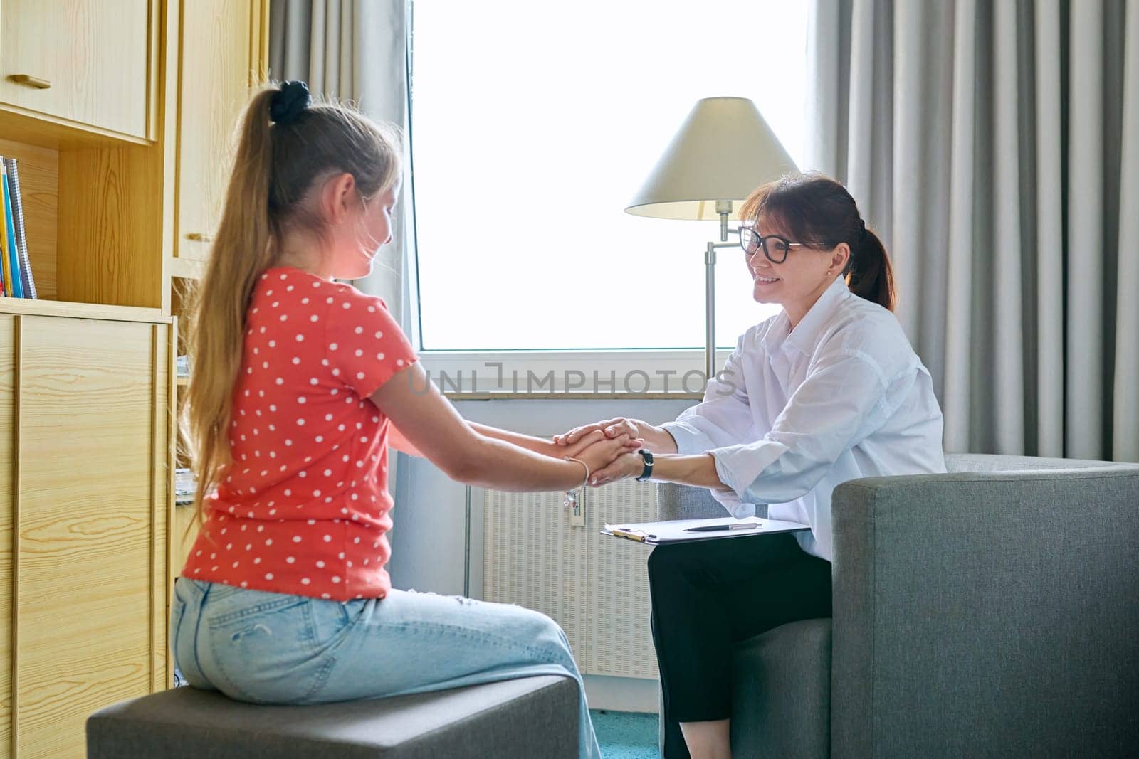 Girl child 10 years old at therapy session with psychologist. School counselor talking to child, listening, helping with problem. Mental health, childhood, schoolchildren, psychology, psychotherapy