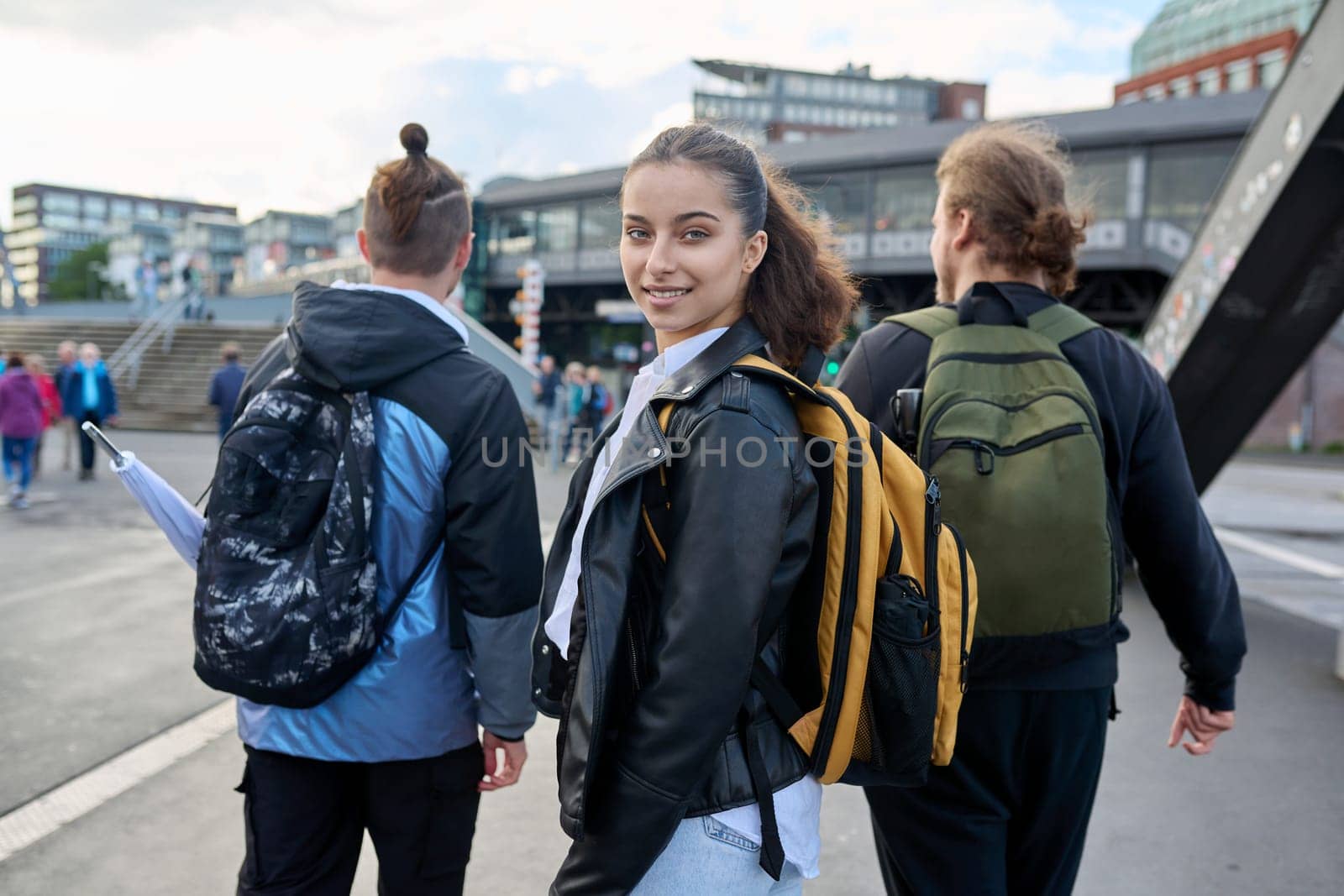 Portrait of teenage high school student, smiling confident girl 16, 17 years old with backpack looking at camera outdoor, on street of modern city. Urban life, adolescence, education, youth concept