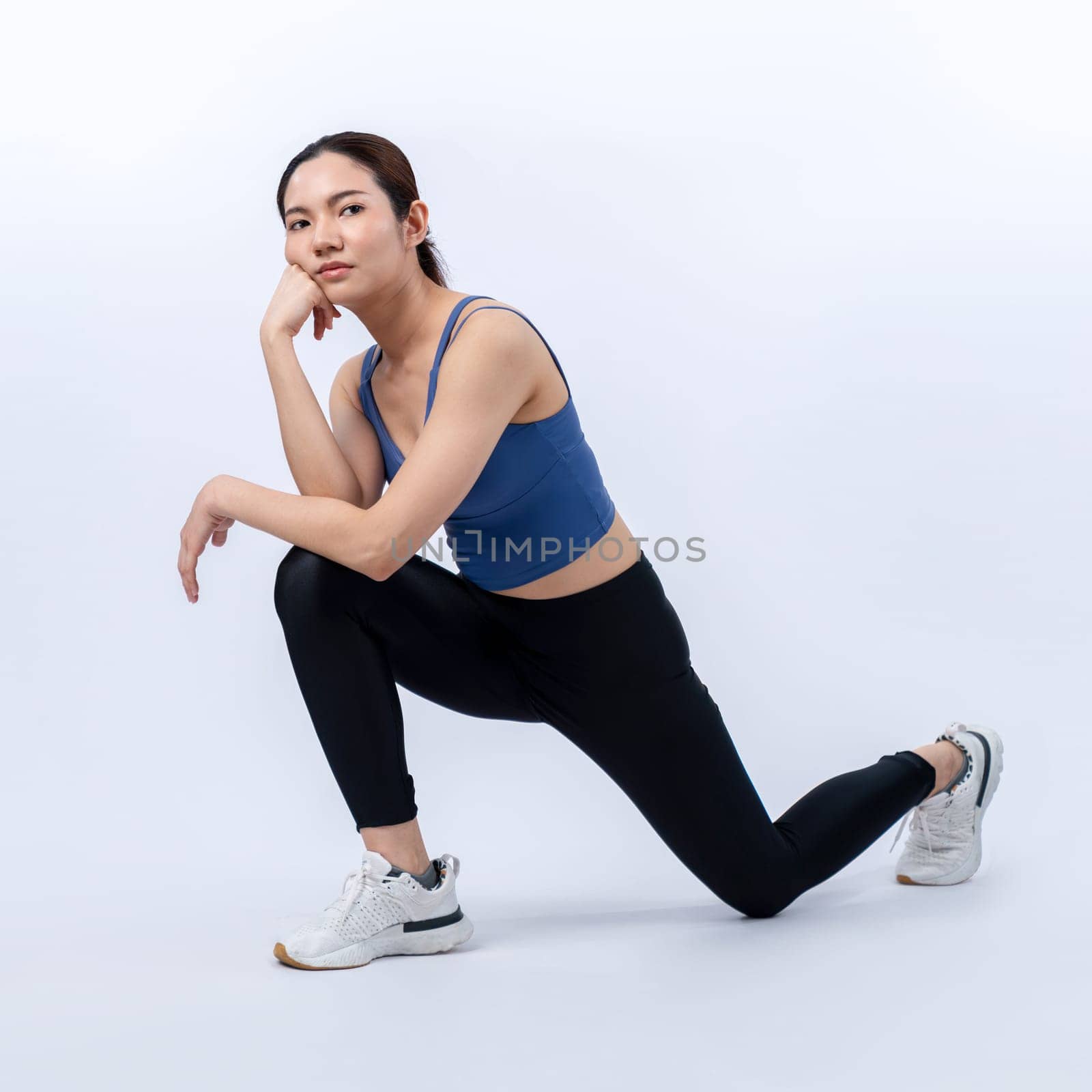 Young attractive asian woman in sportswear stretching before fitness exercise routine. Healthy body care workout with athletic woman warming up on studio shot isolated background. Vigorous