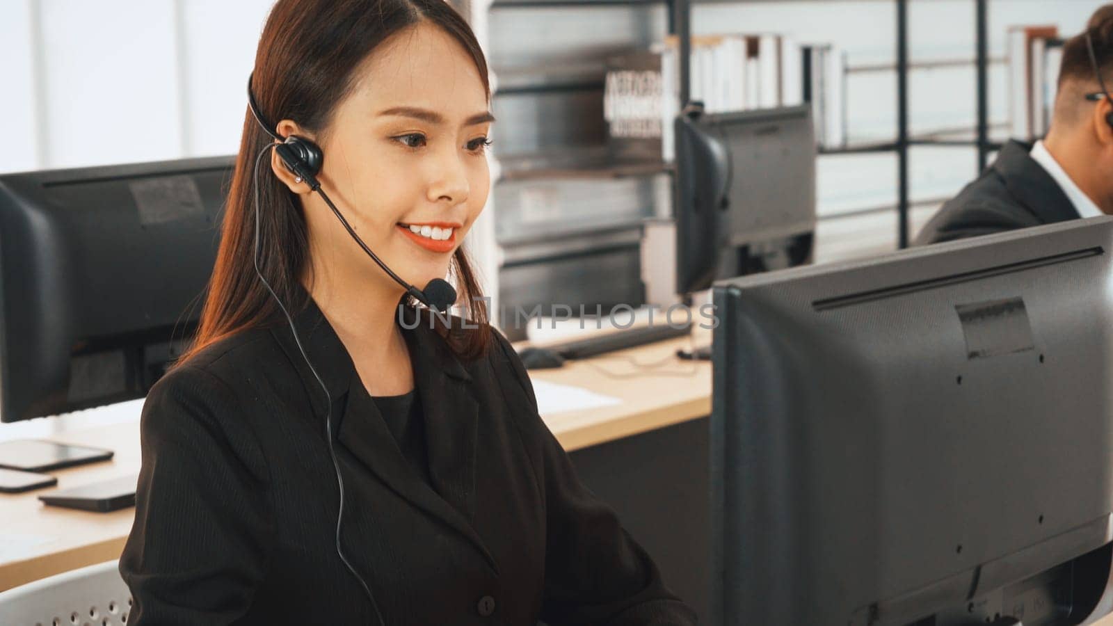 Business people wearing headset working in office to support remote customer or colleague. Call center, telemarketing, customer support agent provide service on telephone video conference call. Jivy