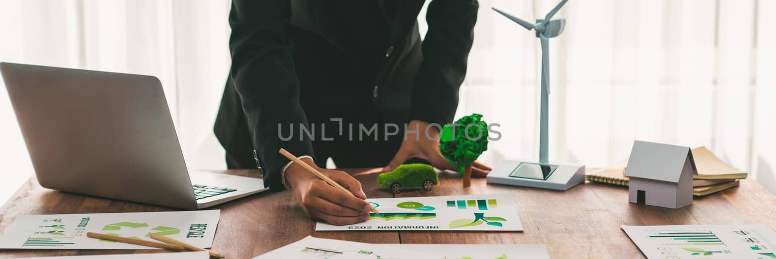 Businessman planning for green business strategy in office with paper documents focused on eco-friendly and energy sustainable policy to reduce CO2 emission for green environment. Trailblazing