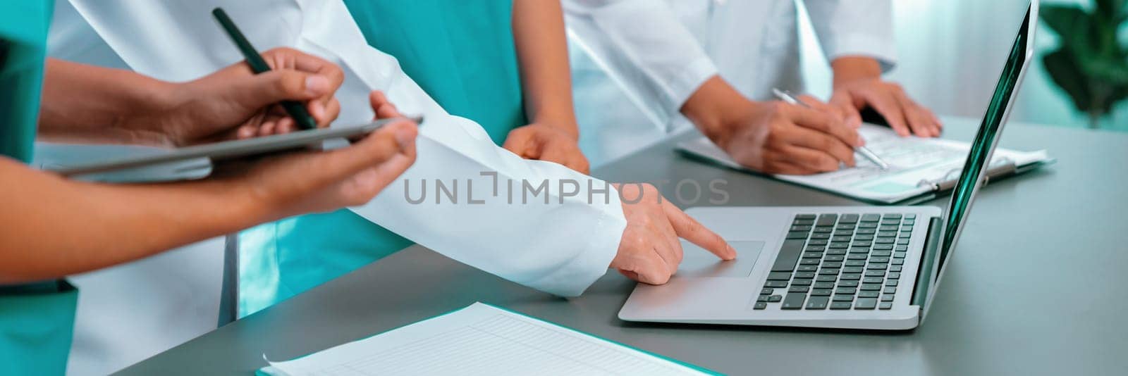 Doctor and nurse in medical meeting discussing strategic medical treatment plan together with report and laptop. Medical school workshop training concept in panoramic banner. Neoteric