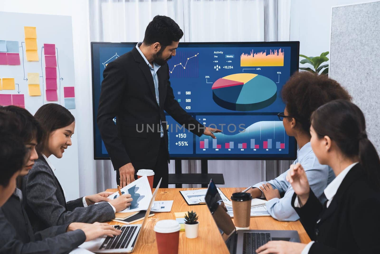 Businessman presenting data analysis dashboard display on TV screen in modern meeting for marketing strategy. Business presentation with group of business people in conference room. Concord