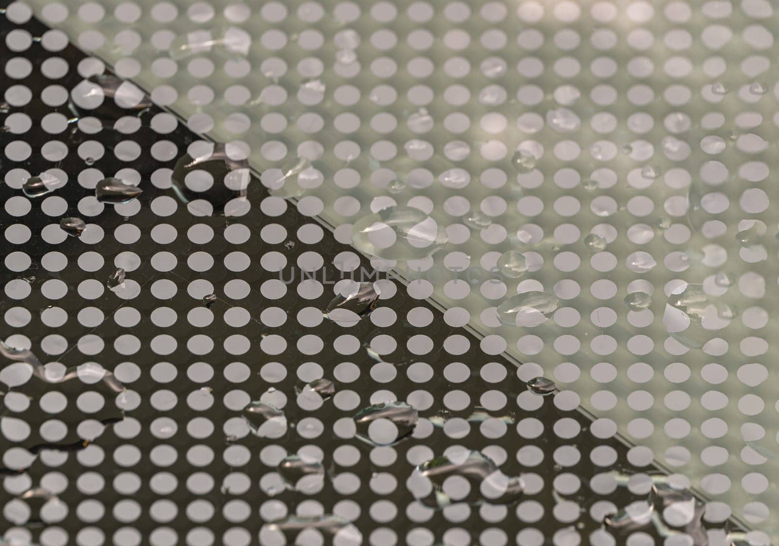 Detail of Water droplets caused by rain perched on surface of the Glass. Rain water drops on a Glass floor, Natural Pattern of dew drops or raindrops on galss background for wallpaper, Poster and Space for text, Selective focus.