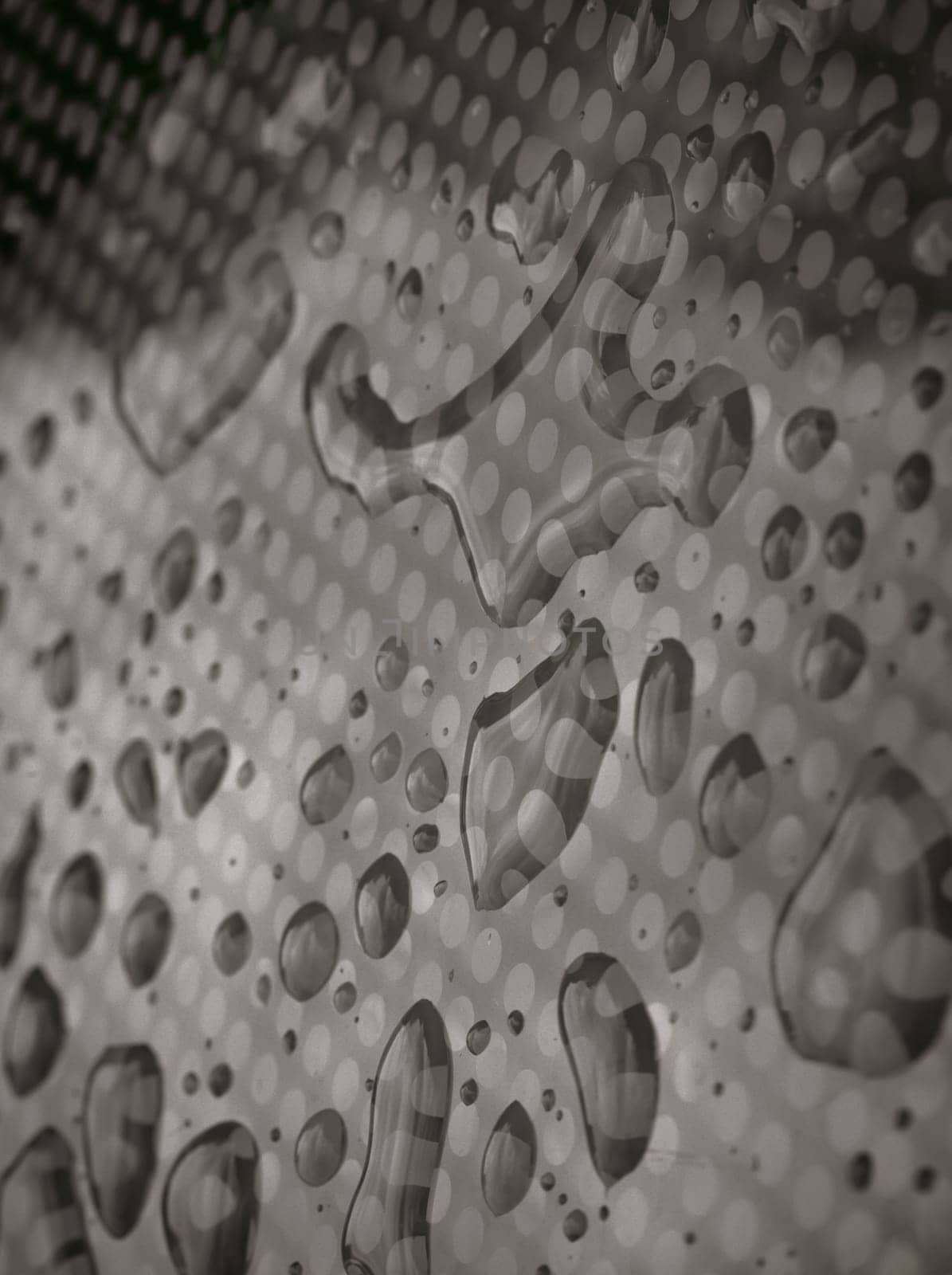 Rain water drops on a Glass floor. Detail of Water droplets caused by rain perched on surface of the Glass. Natural Pattern of dew drops or raindrops on galss background for wallpaper, Poster and Copy space, Selective focus.