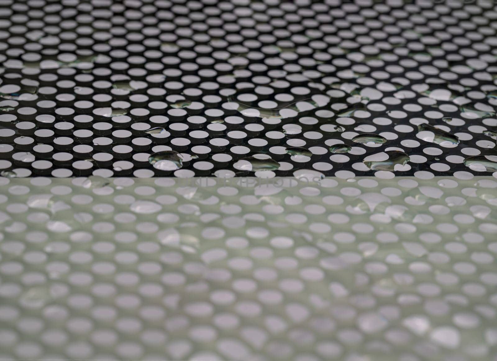 Detail of Water droplets caused by rain perched on surface of the Glass. Rain water drops on a Glass floor, Natural Pattern of dew drops or raindrops on galss background for wallpaper, Poster and Space for text, Selective focus.