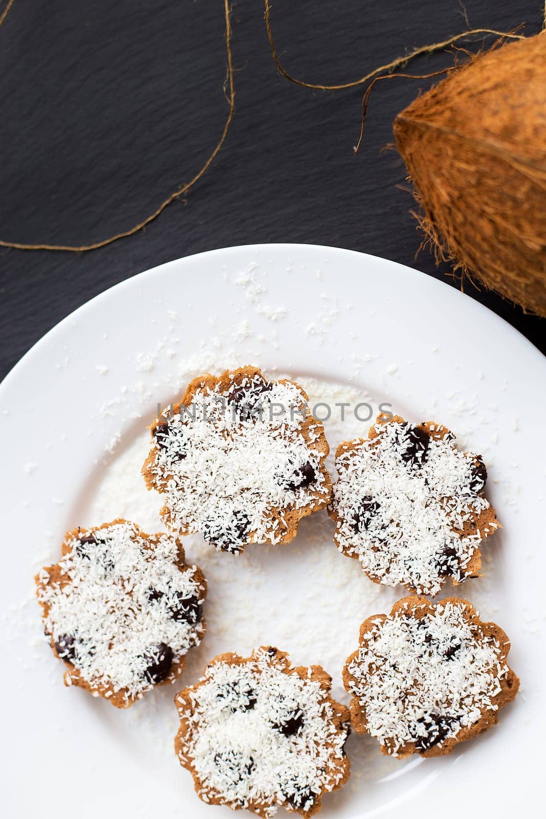 sweet coconut muffins on a white plate on a black board