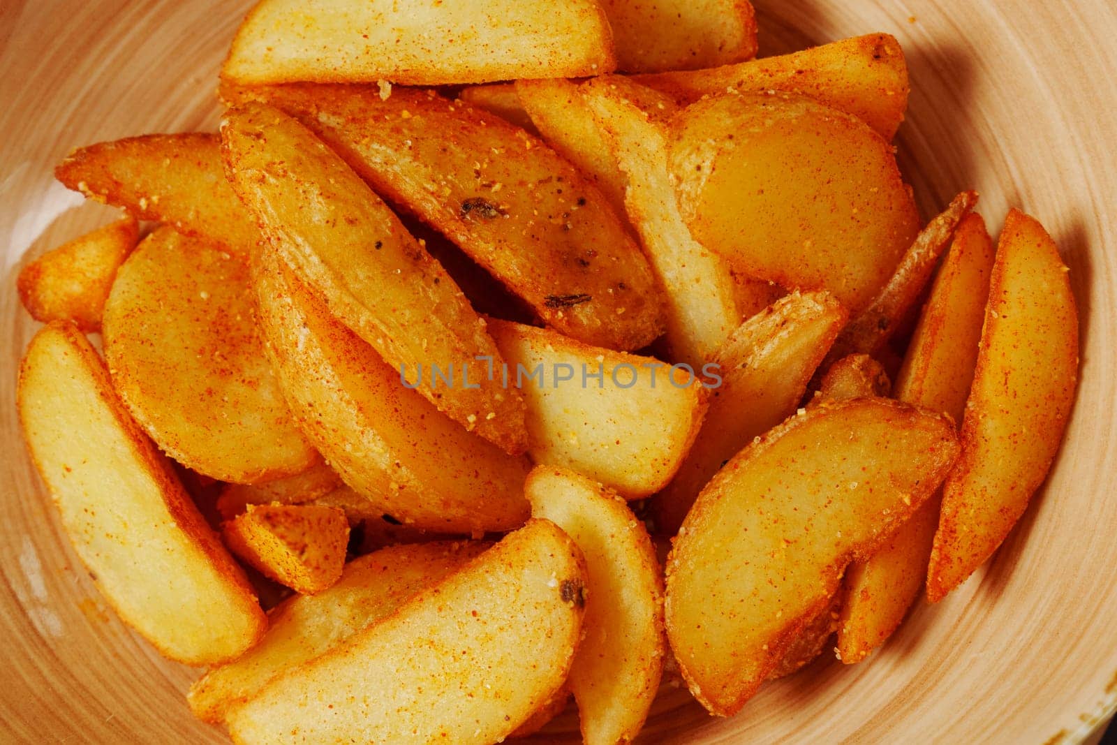 Crispy seasoned potato wedges served in a rustic bowl, a delightful snack perfect for sharing during a cozy gathering