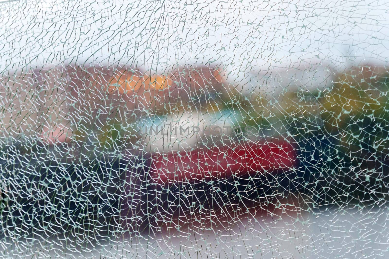 A close-up view of fragmented glass creating an abstract texture while hinting at a vibrant background in the urban environment