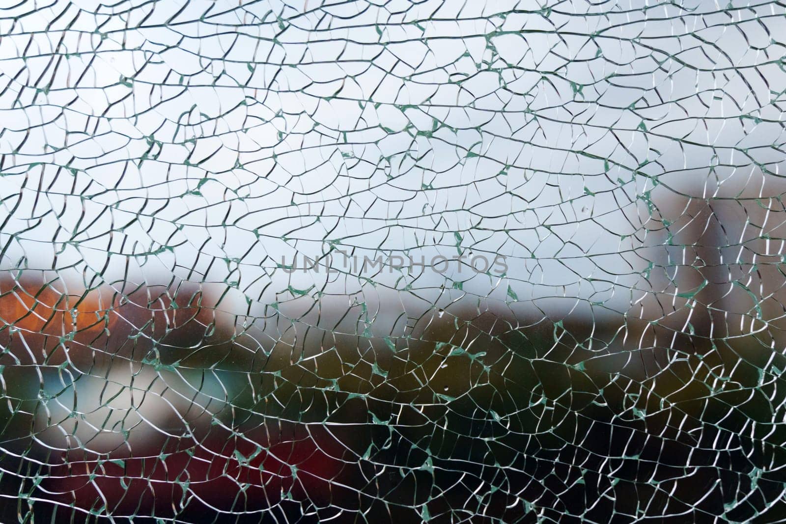 A close-up view of fragmented glass creating an abstract texture while hinting at a vibrant background in the urban environment