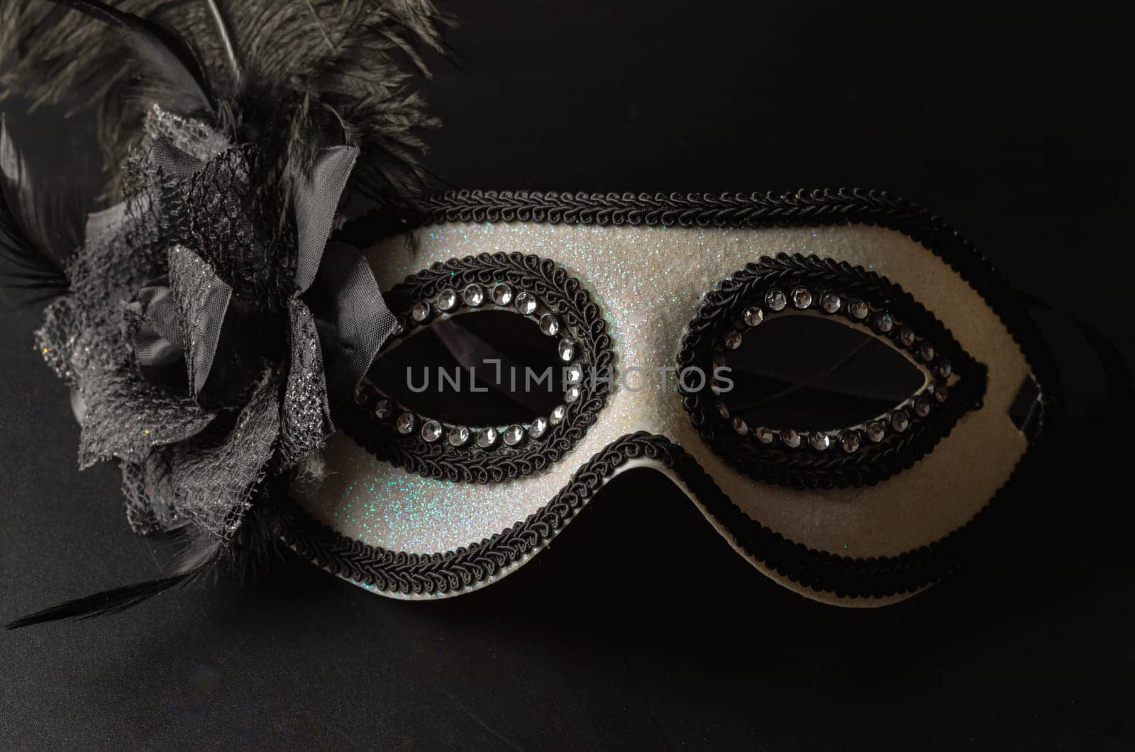 Bangkok, Thailand - 17 Sep, 2024 - Beautiful mysterious venetian mask with feathers design on dark background, Light and Shadow, Space for text. Selective Focus.