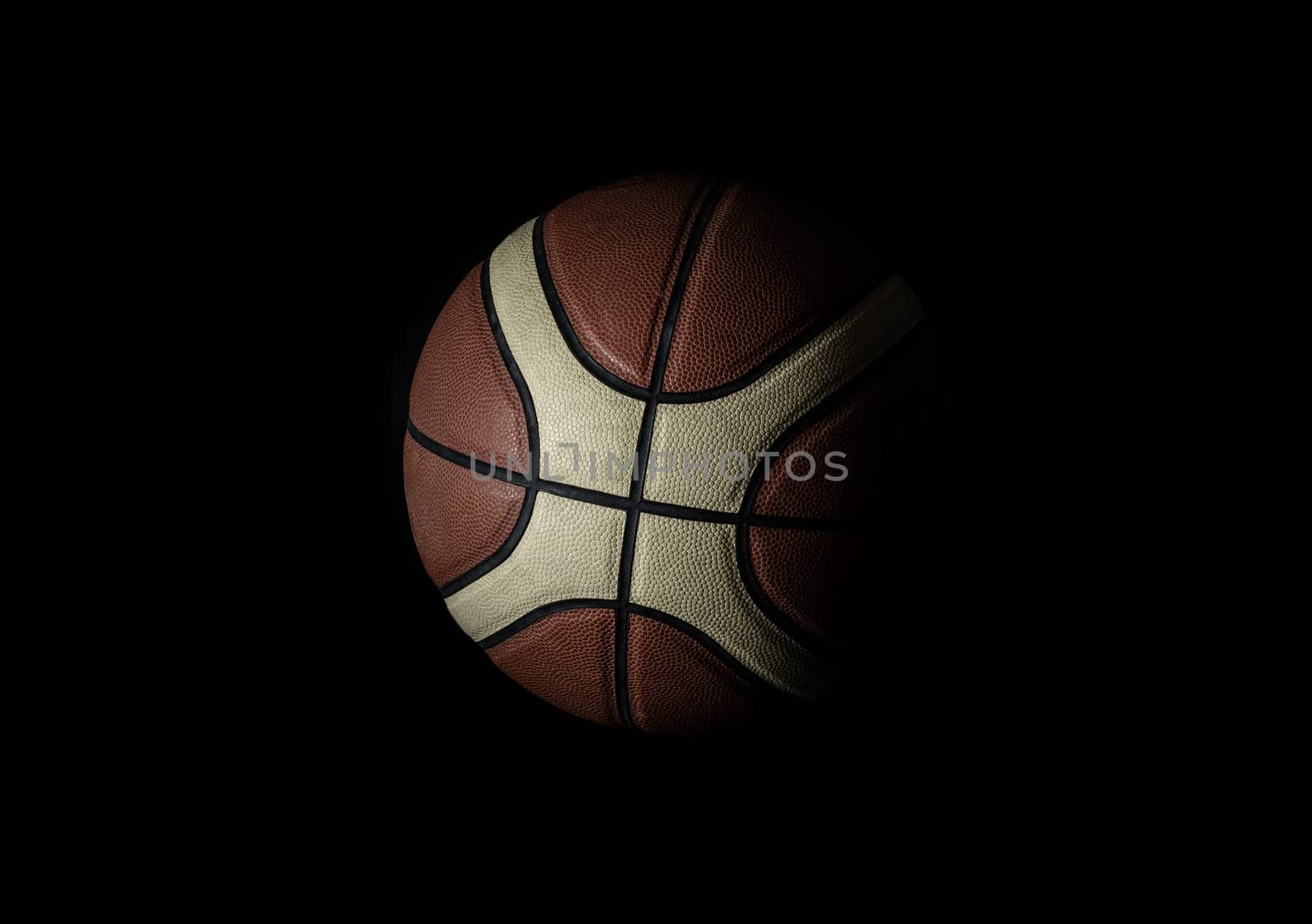Basketball ball in minimalist style isolated on black background. Basketball ball leather texture with bumps pattern background, Light and Shadow, Copy space, Selective focus.