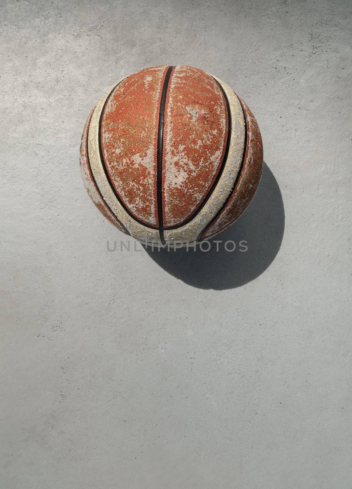 Old basketball ball on cement floor and Natural light. use it as your Wallpaper, Poster and Space for text, Selective focus.