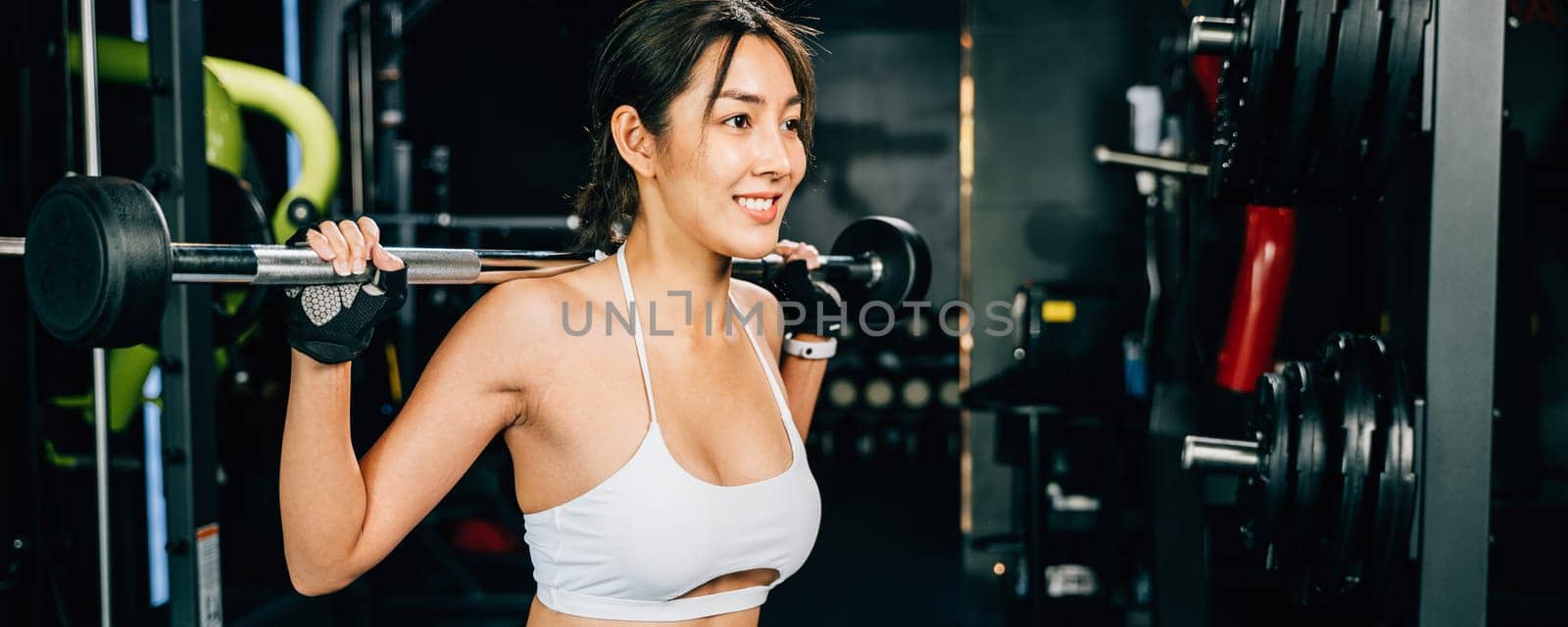 Asian woman muscular guy squat exercise with a lifting barbell in gym, female exercising squatting performing shoulder press lift weight for legs at fitness gym, workout healthy lifestyle concept
