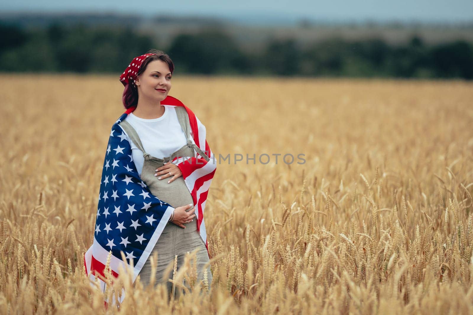 Pregnant Patriot Woman Standing With American National Flag In Rural Wheat Field landscape. Symbol of democracy, independence, USA, 4th July celebration, US banner, election, America, labor