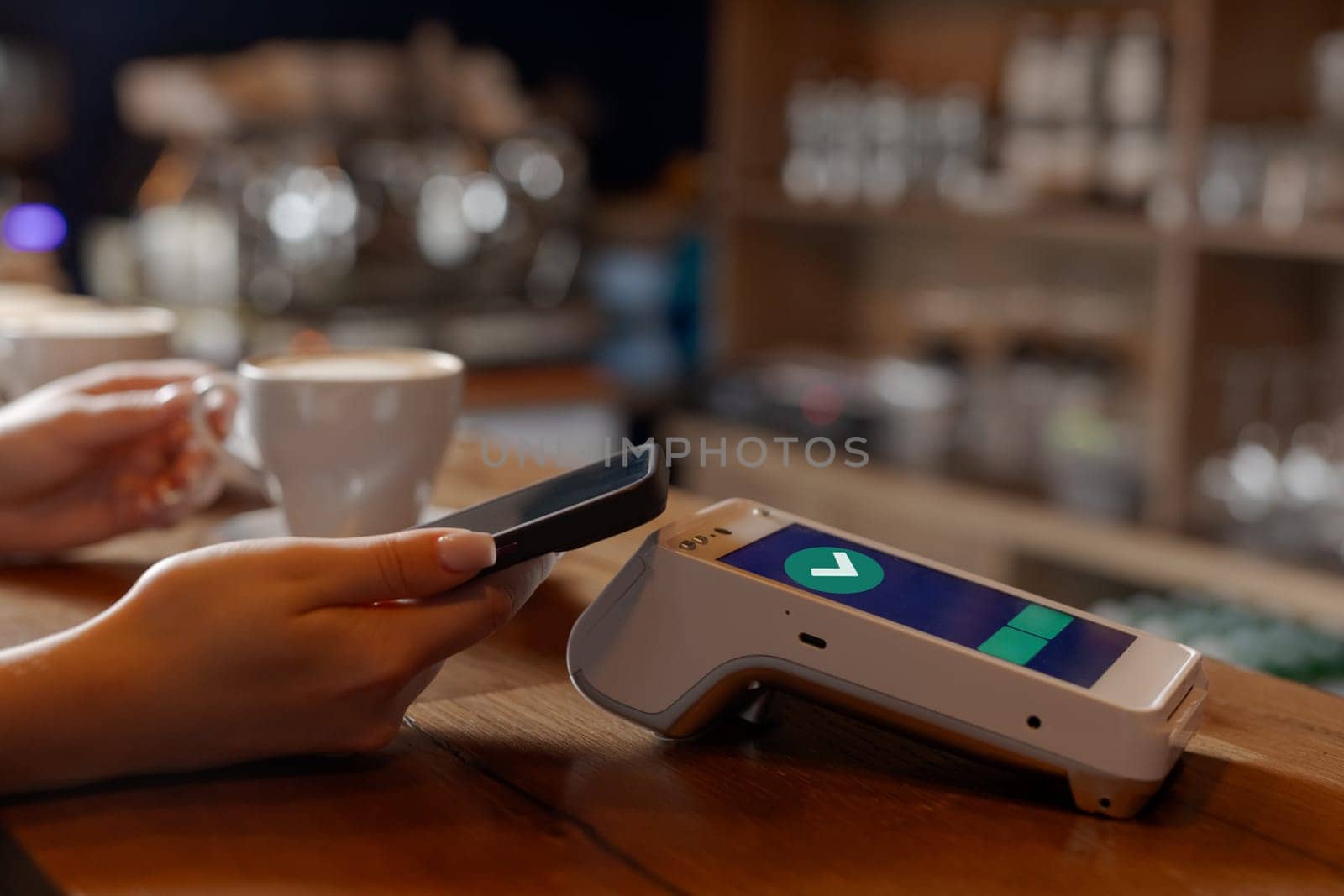 customer makes contactless NFC payment by phone through terminal in cafe, concept successful payment, electronic wallet