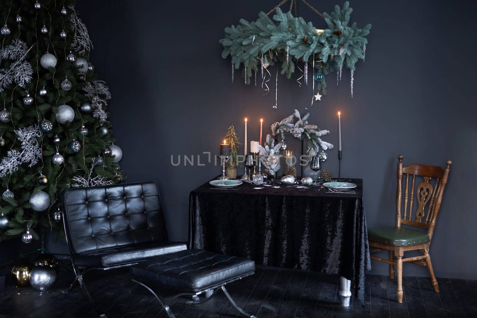 New Year stylish interior in dark style, New Year tree with New Year toys and decorated table in dark style