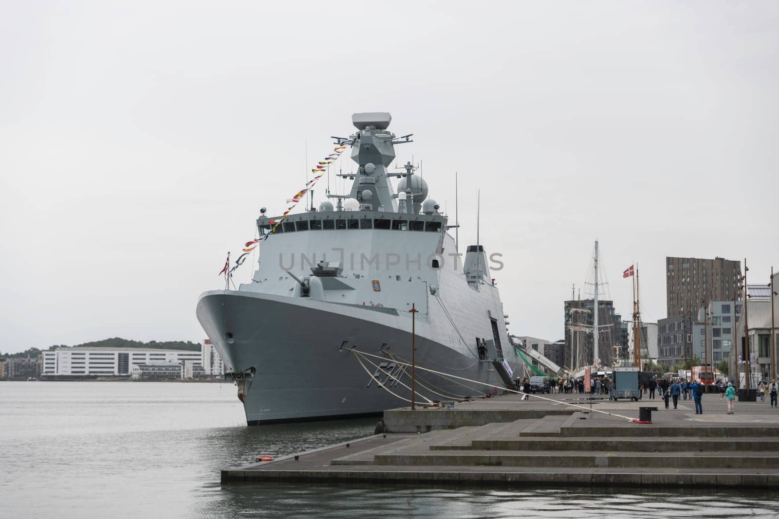 aalborg,denmark,22-08-2024:the f341 war ship denmark in aalborg,naval warship is docked at an urban waterfront, showcasing maritime technology. The harbor scene captures the essence of coastal infrastructure and modern naval presence.