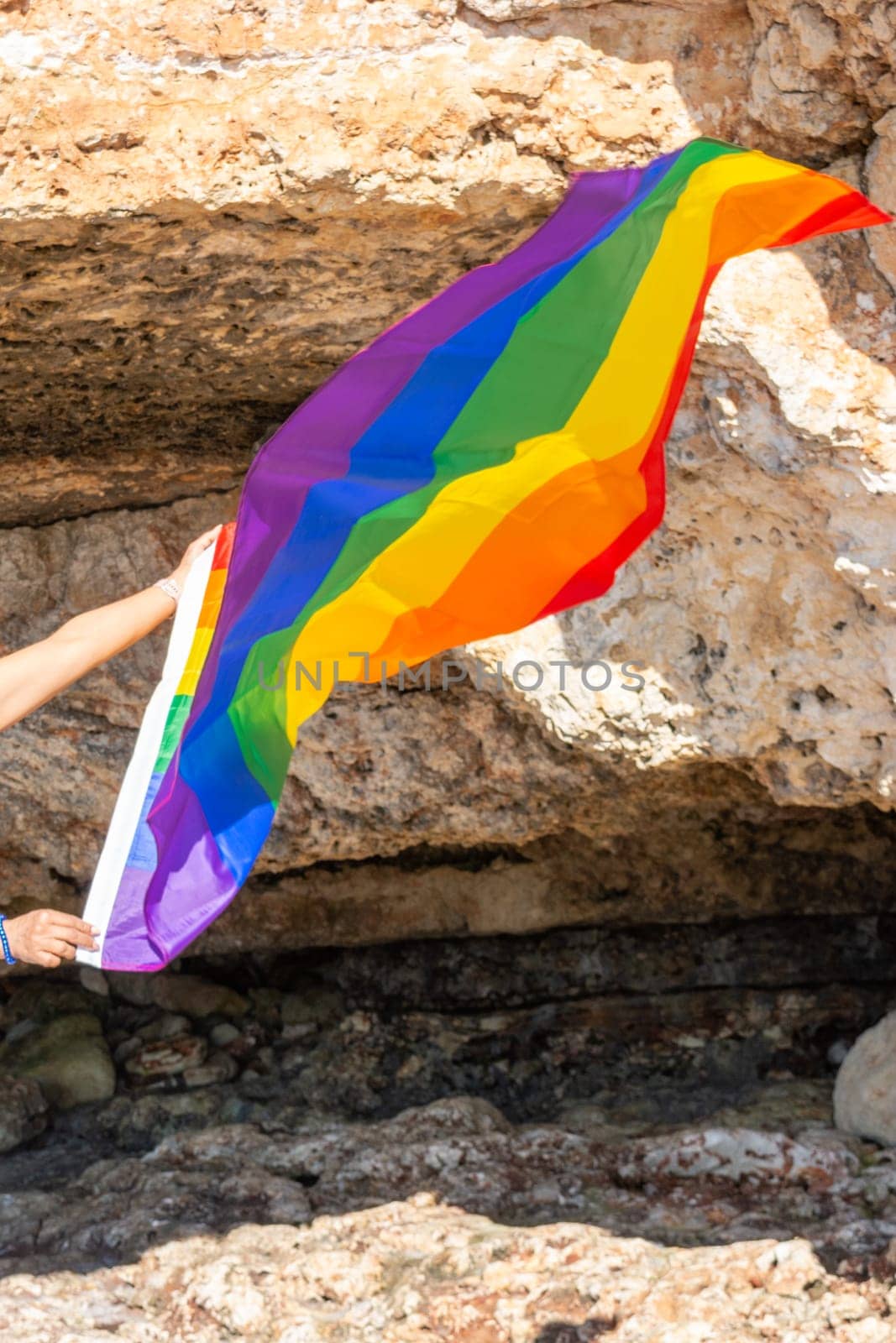 woman, middle aged, outdoors waving pride flag, concept of libertat, equality.