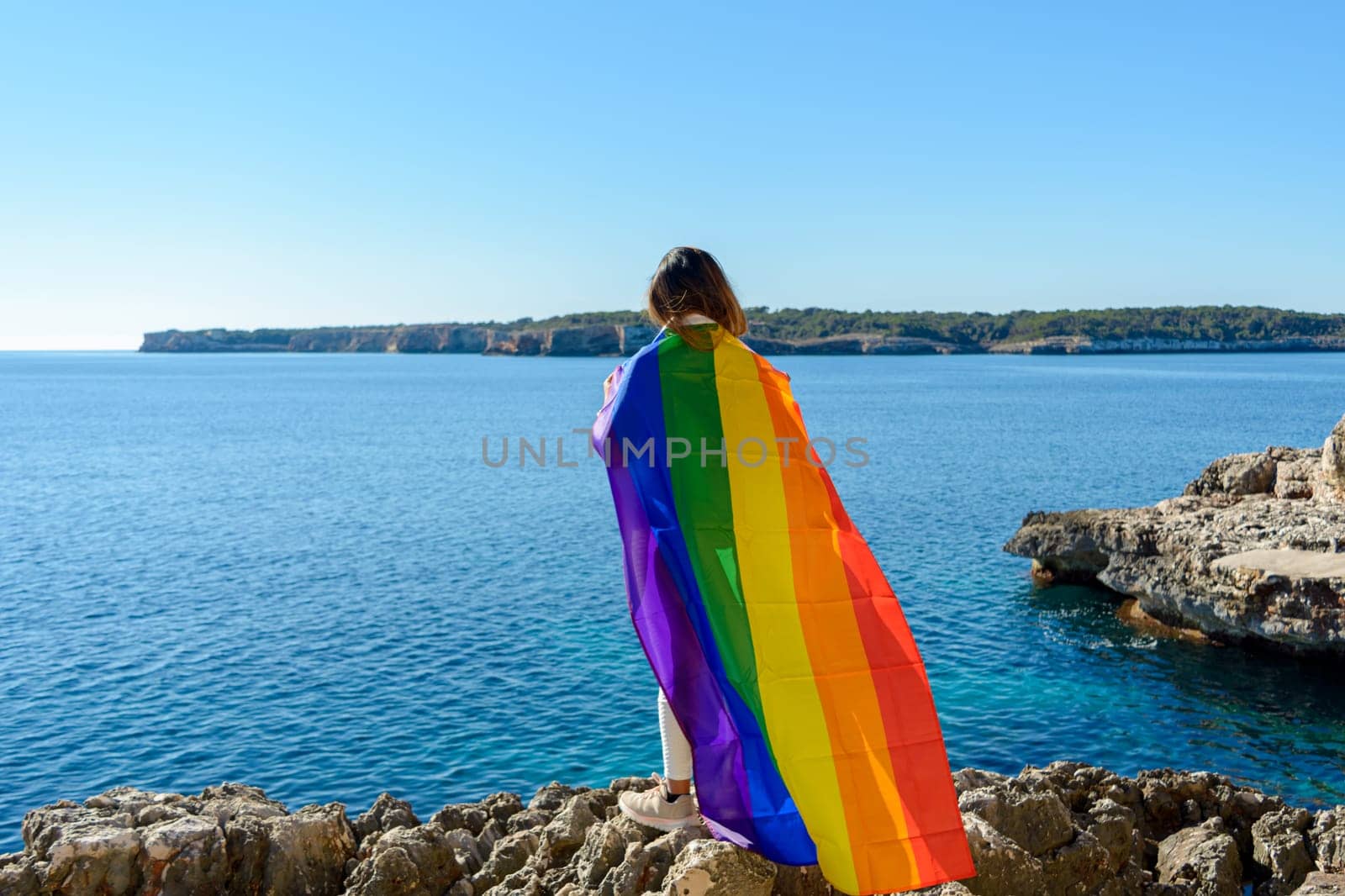 woman, middle aged, outdoors waving pride flag, concept of libertat, equality.