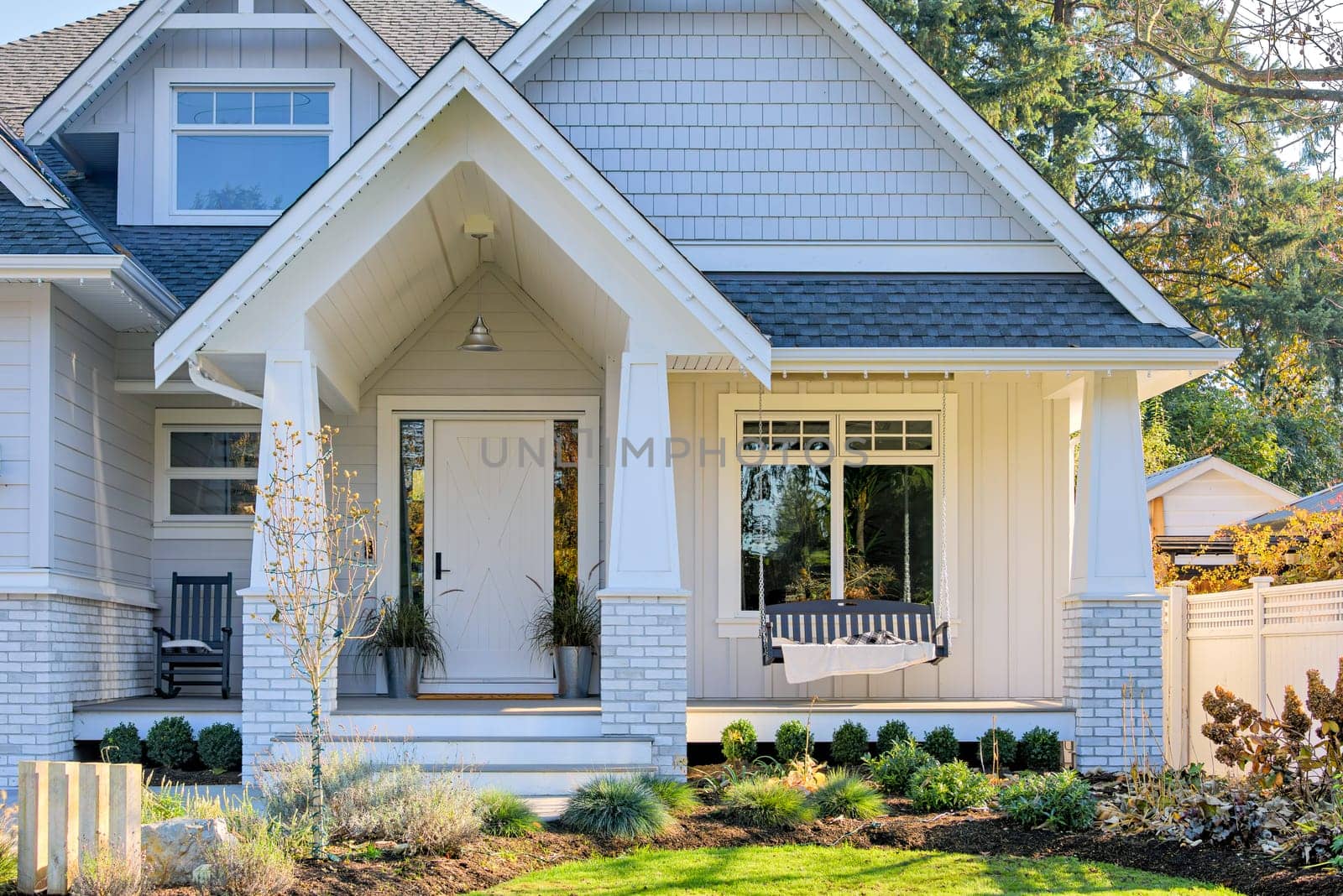 Residential house with open patio under the porch. Detached residential house on bright sunny autumn day