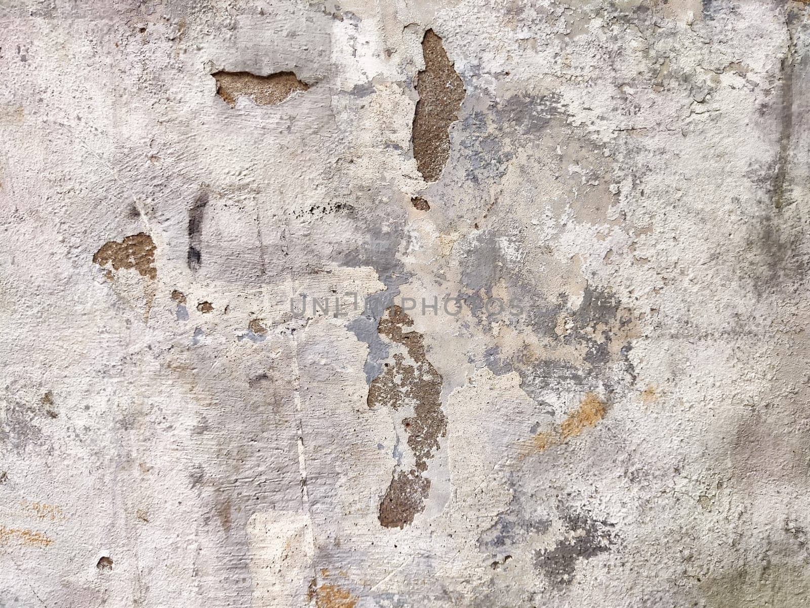 A weathered wall surface displaying a unique texture, showcasing cracks and peeling paint, ideal for backgrounds or design elements.