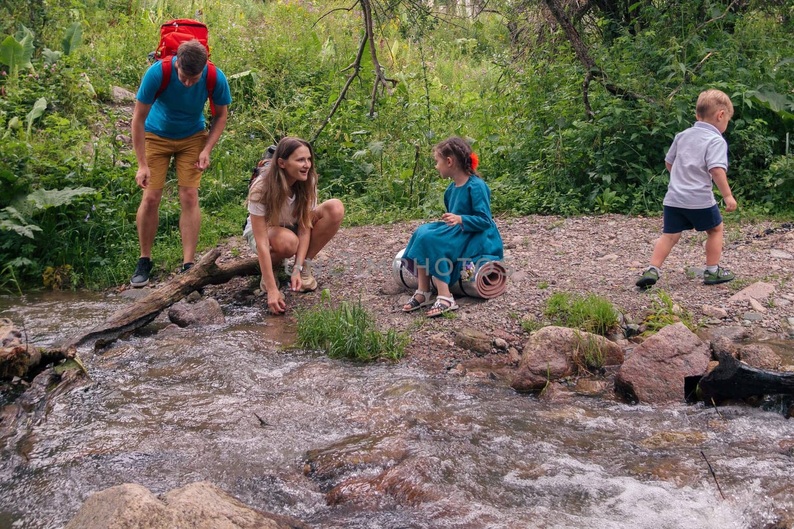 A happy family enjoys a delightful day by the peaceful stream, exploring natures beauty and bonding in joy