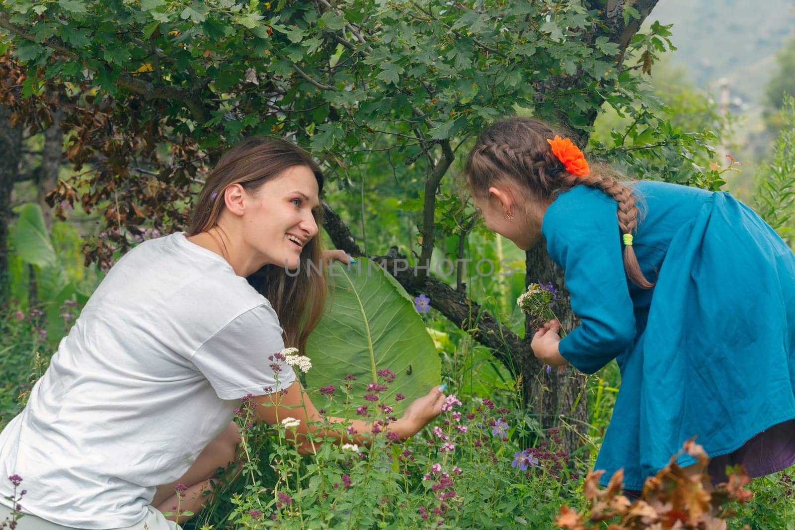 A heartwarming scene of a mother and daughter joyfully discovering flowers in a vibrant garden of greenery