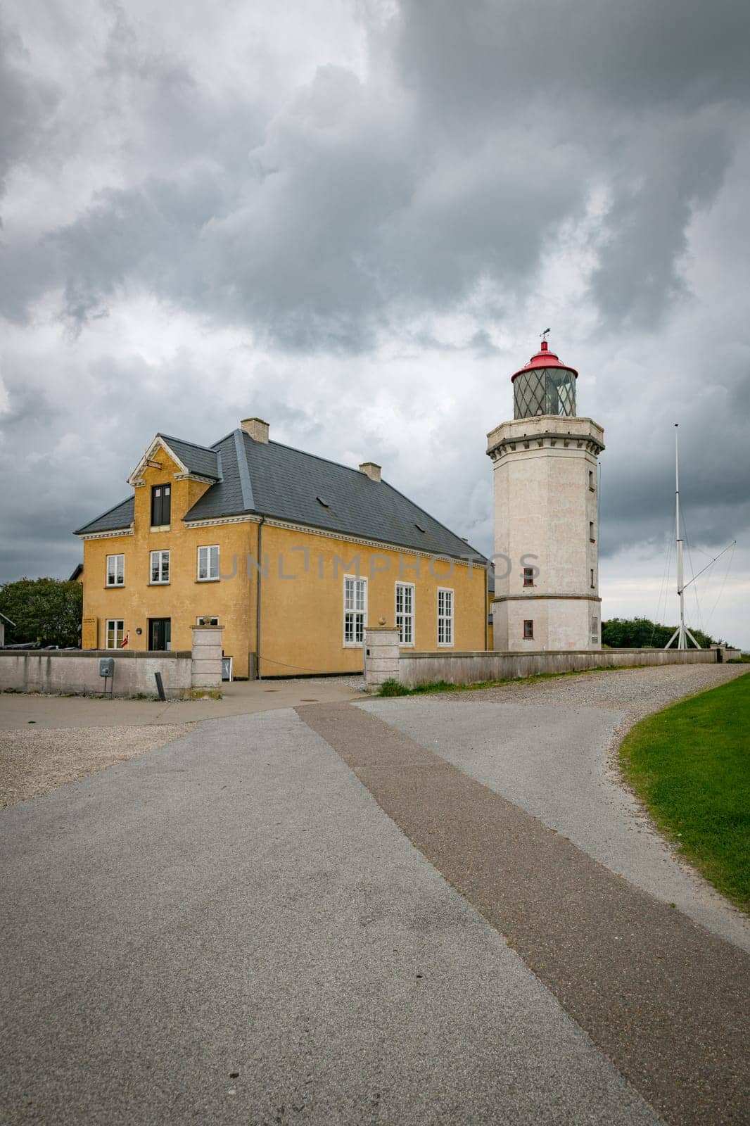 the old Historic Lighthouse and Yellow Building Under Cloudy Sky in hansholm in the thy national park in denmark
