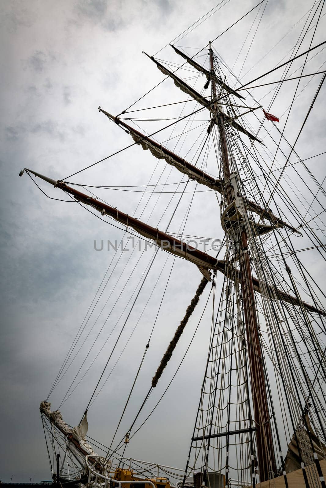 A magnificent view of towering ship masts extending into a gray, cloudy sky, capturing the essence of maritime adventure and nautical history.