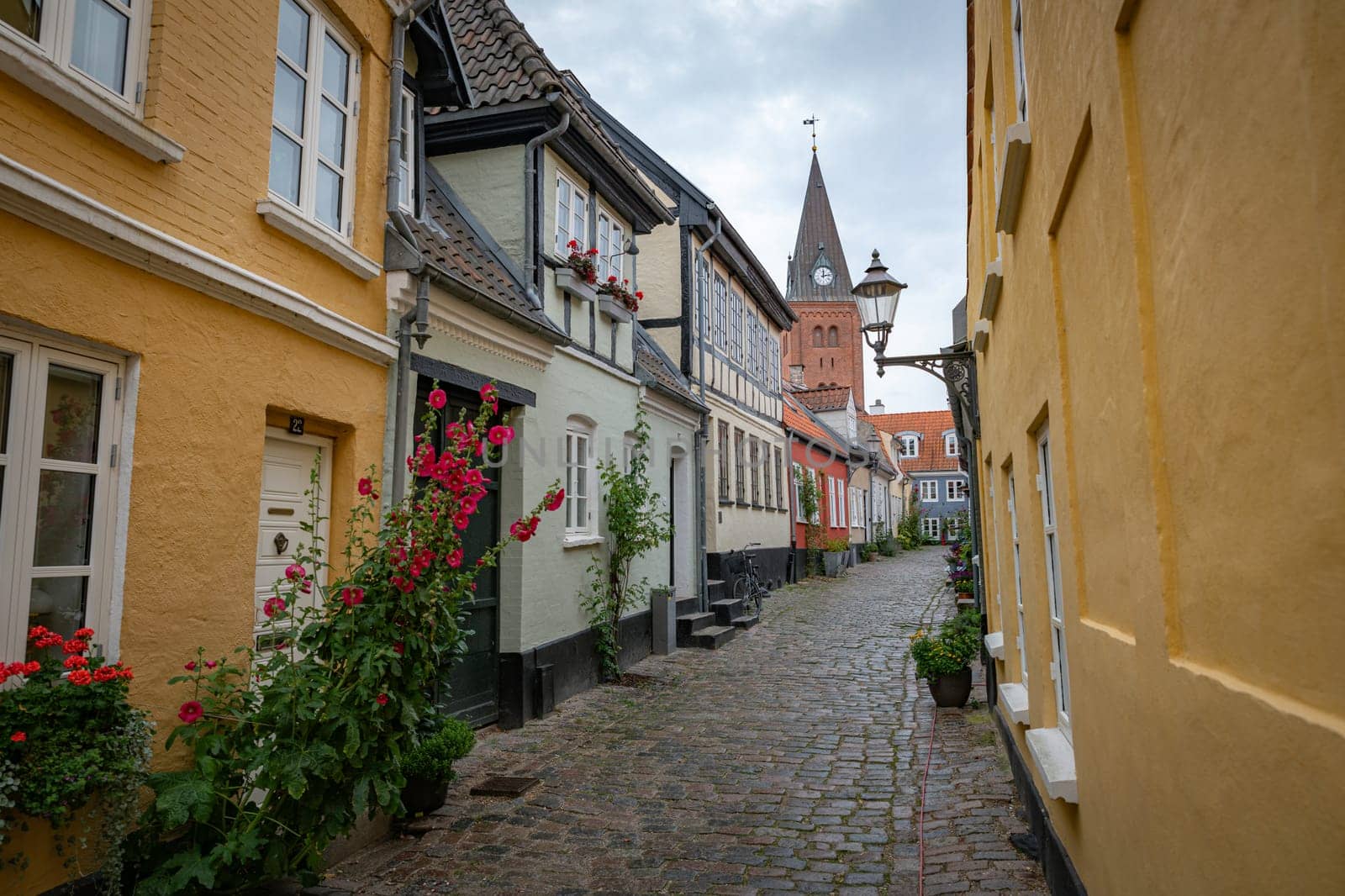 typical street in denmark aalborg with red yellow and blue houses and church
