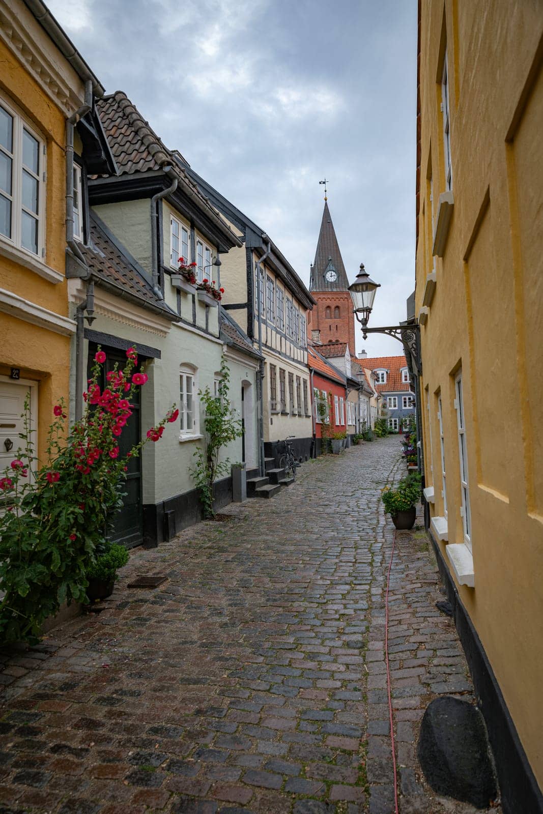 typical street in denmark aalborg with red yellow and blue houses and church