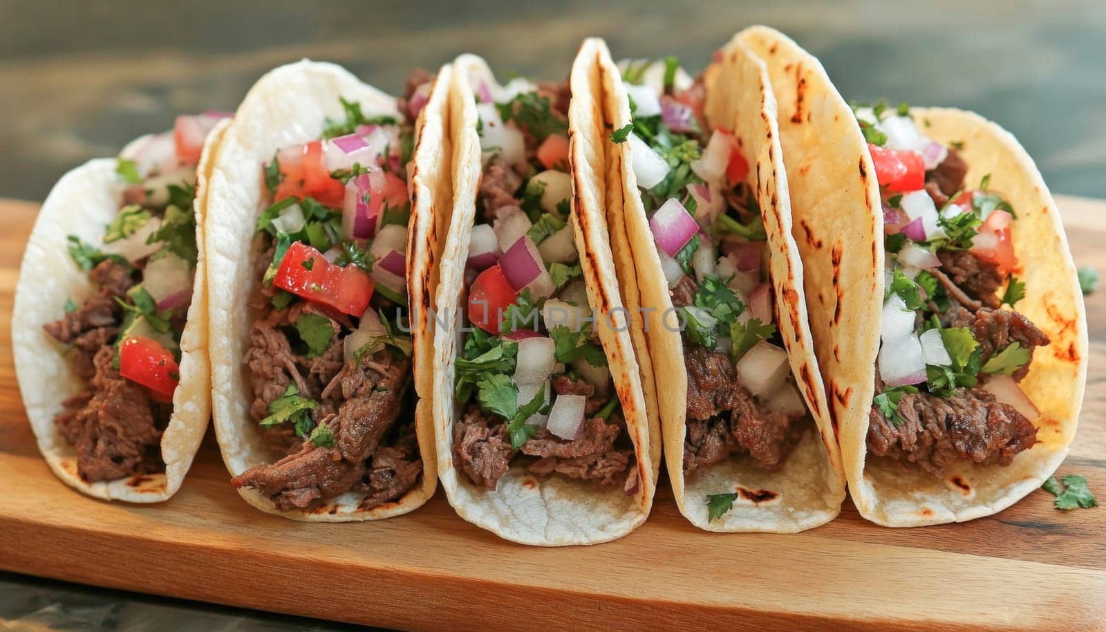 Four delicious tacos on a wooden board are waiting to be eaten