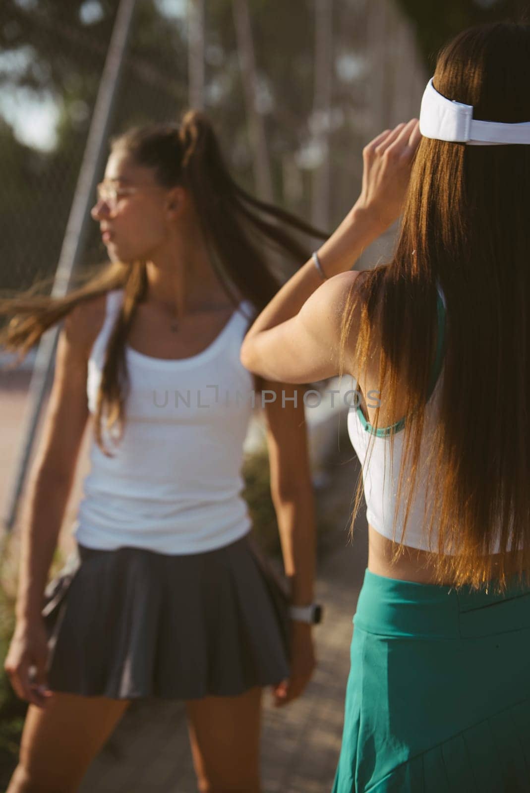 Two fashionable women are enjoying their leisure time at a park, radiating youthful energy and unique style